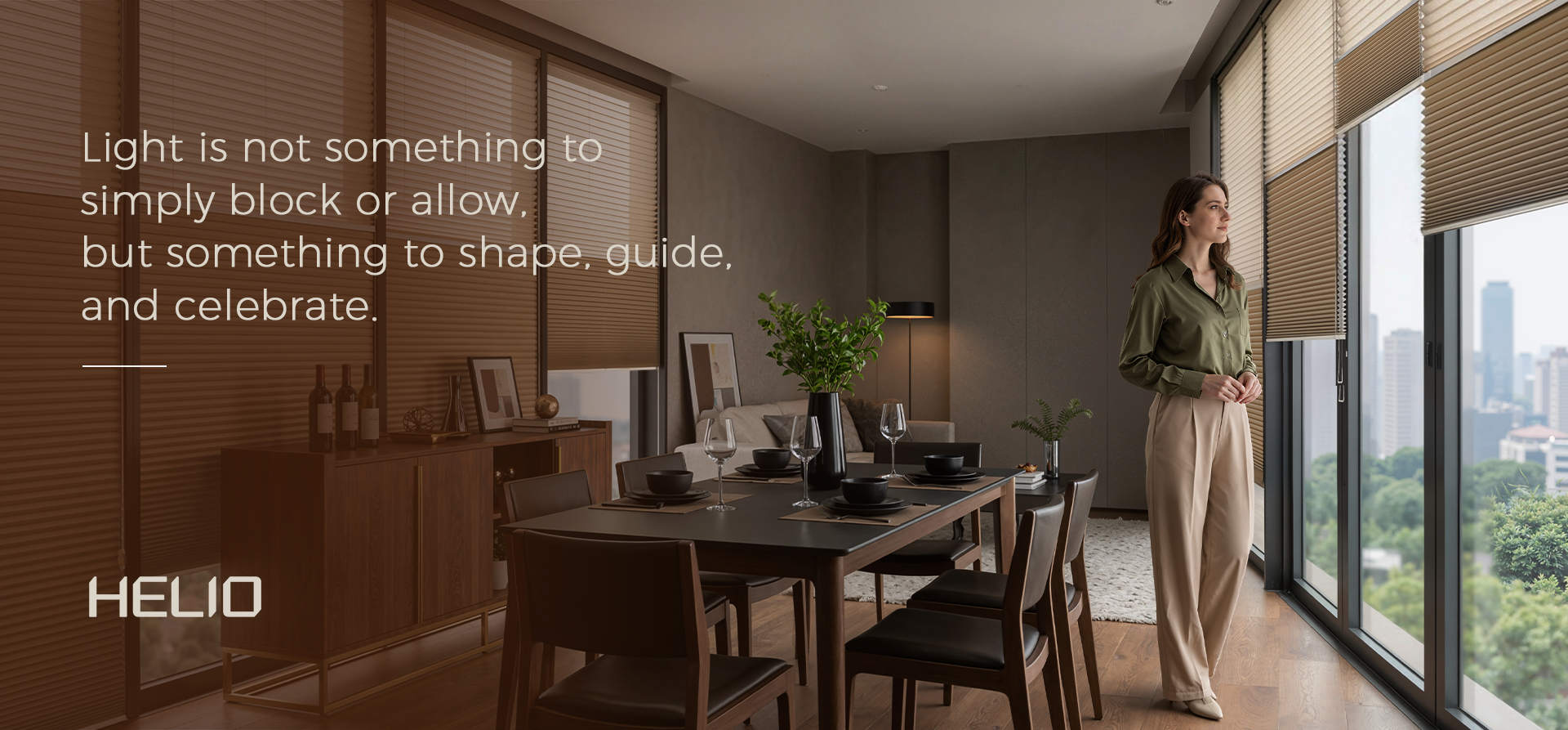 A person standing by a large window with modern blinds in a dining room, with the brand name HELIO displayed.