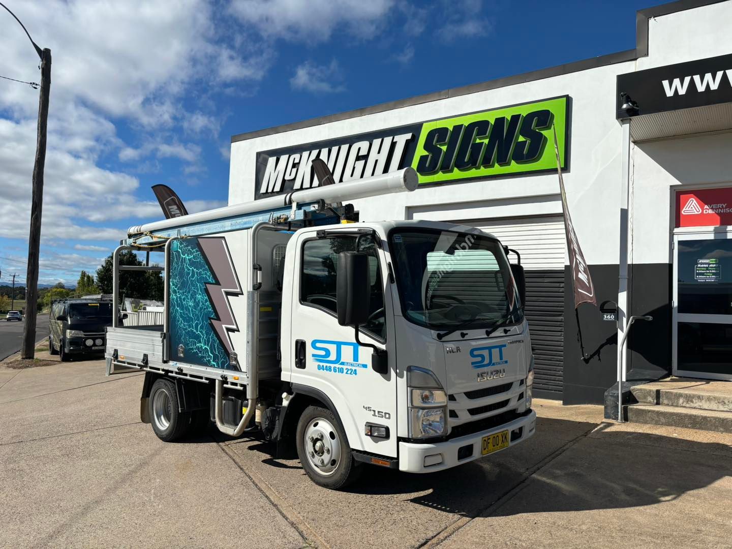 A white truck is parked in front of a building — McKnight Signs In Hillvue, NSW