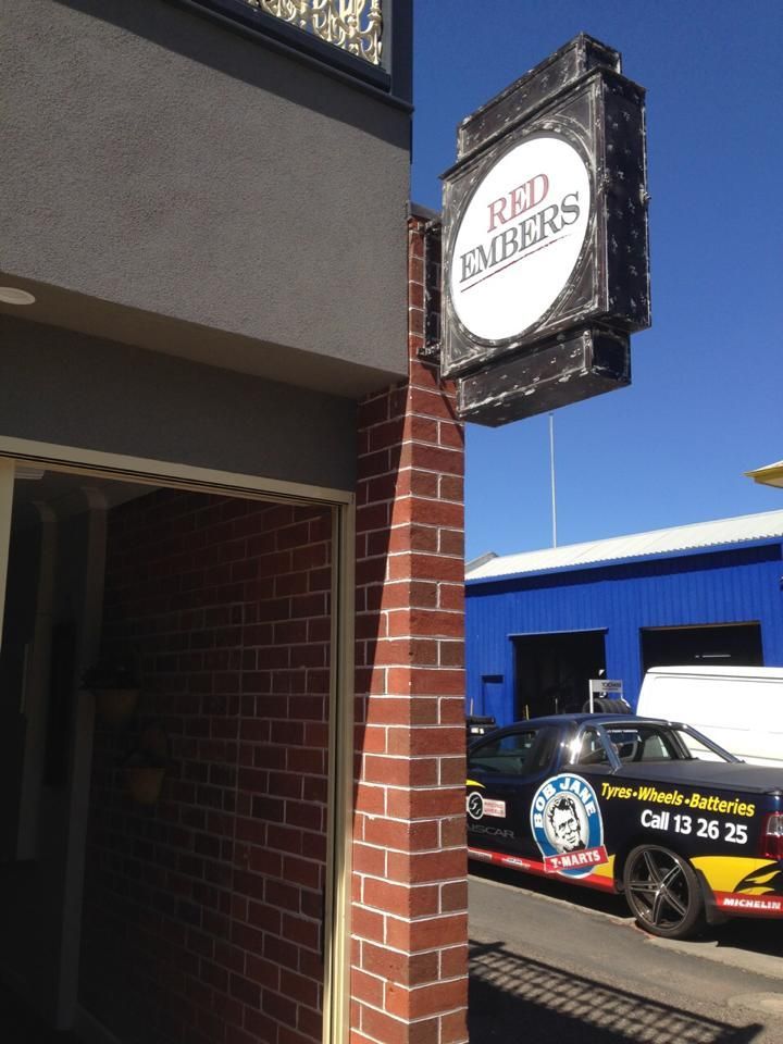 A Brick Building With A Sign That Says Red Embers — McKnight Signs In Hillvue, NSW