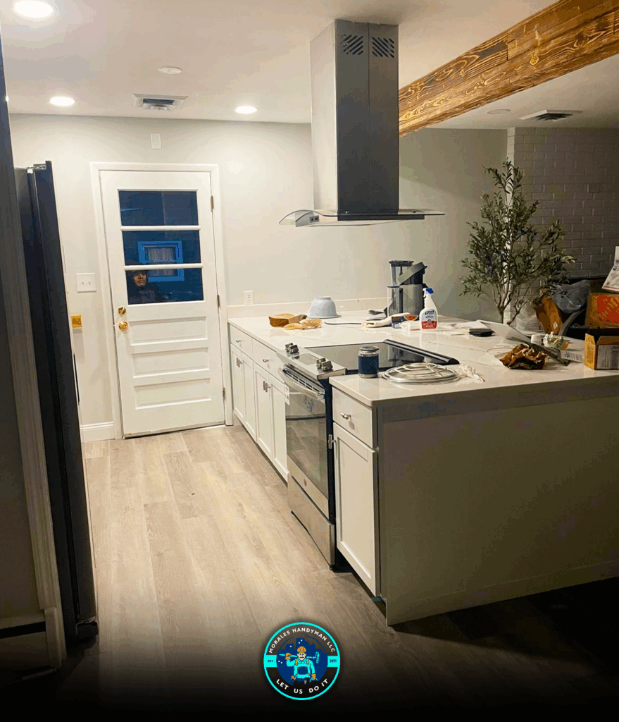 Kitchen with white cabinets, stainless steel appliances, and a light-colored countertop. A door is on the left.