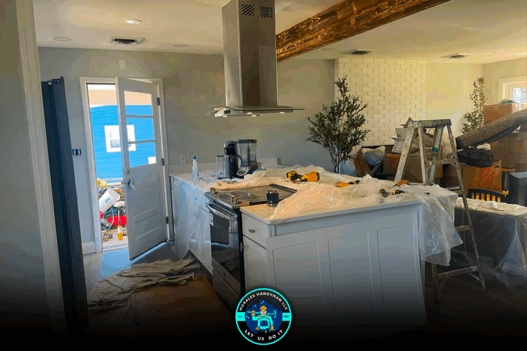 Kitchen renovation in progress, white cabinets, island with stovetop, open door to exterior, tools and debris visible.