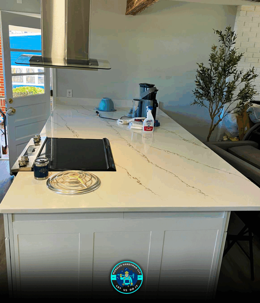 Kitchen island with white countertop, cooktop, and stainless steel range hood.