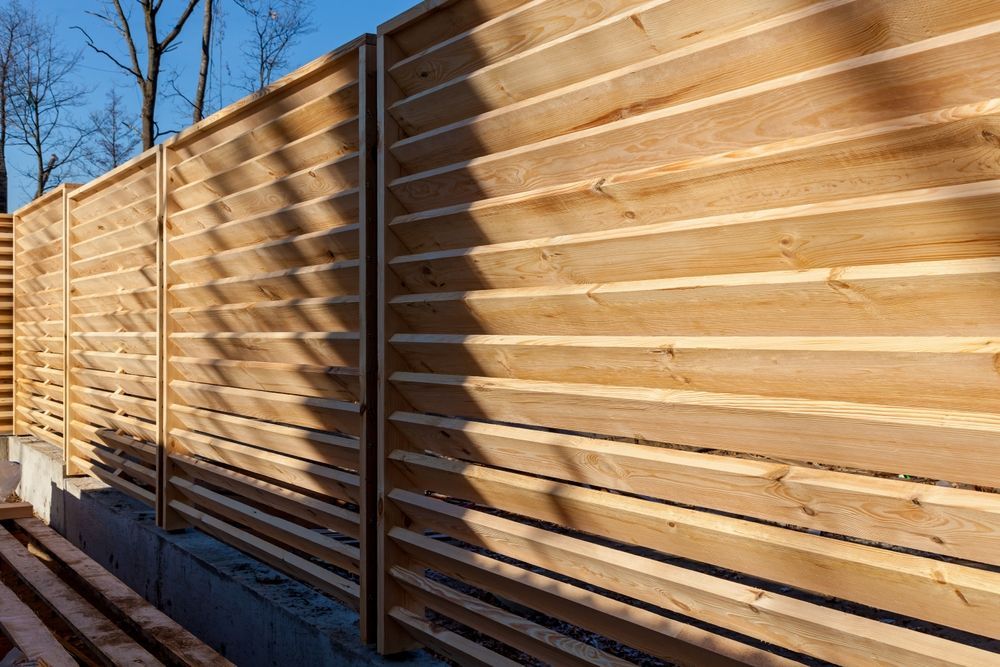 Wooden horizontal slat fence in sunlight.