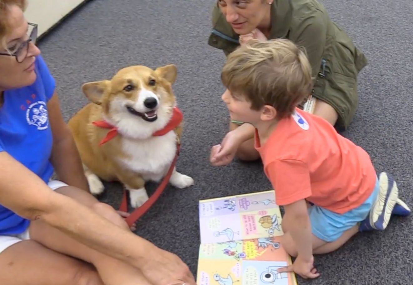 Children read to attentive dog at Brewster Ladies Library Tales to Tails day.