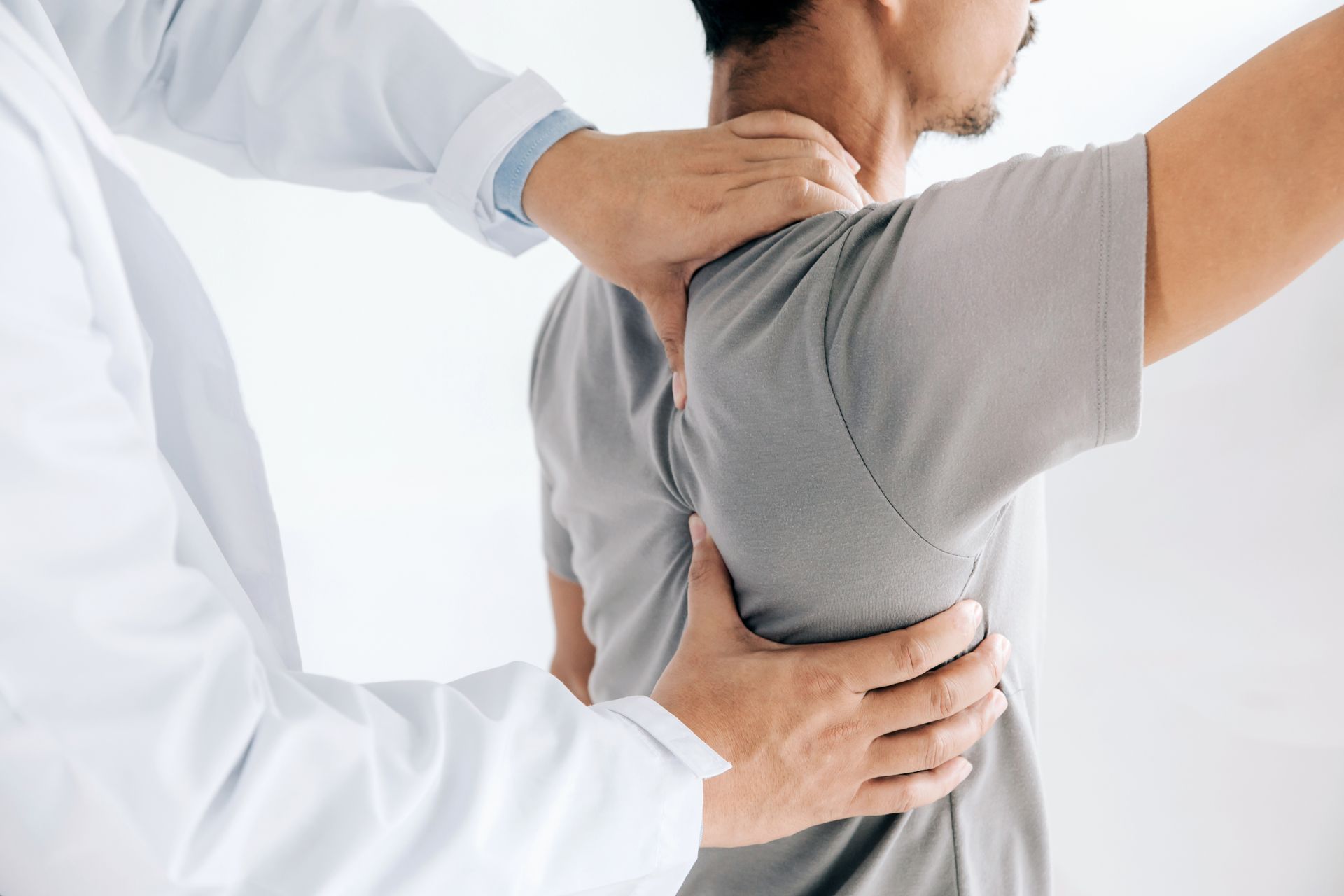 A man is getting his shoulder examined by a doctor.