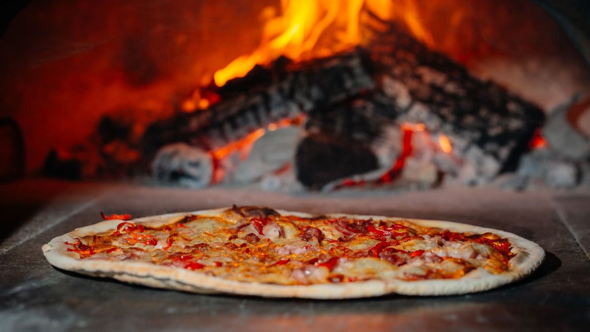 Pizza alla romana in cottura in forno a legna
