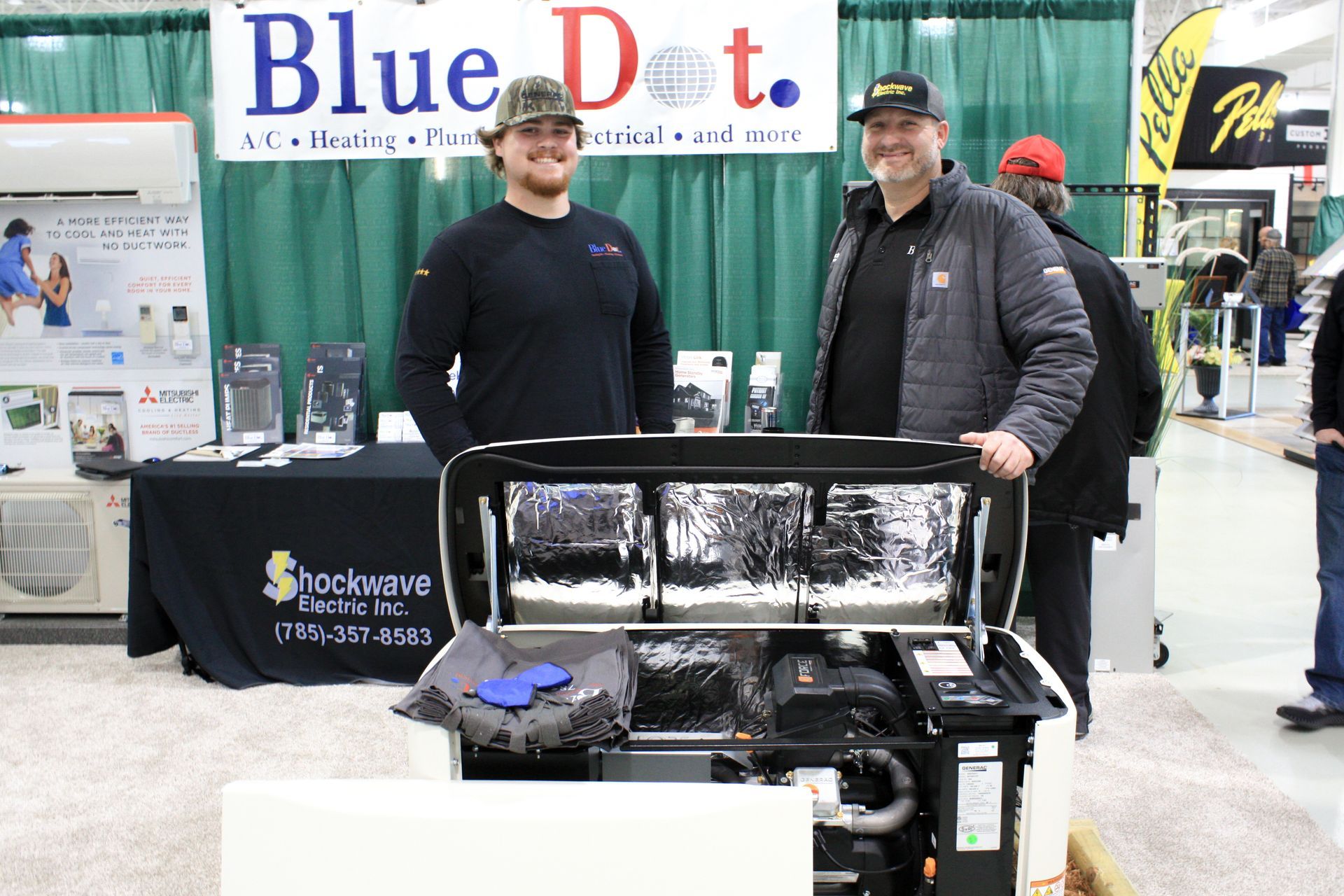 Two men are standing in front of a blue dot sign