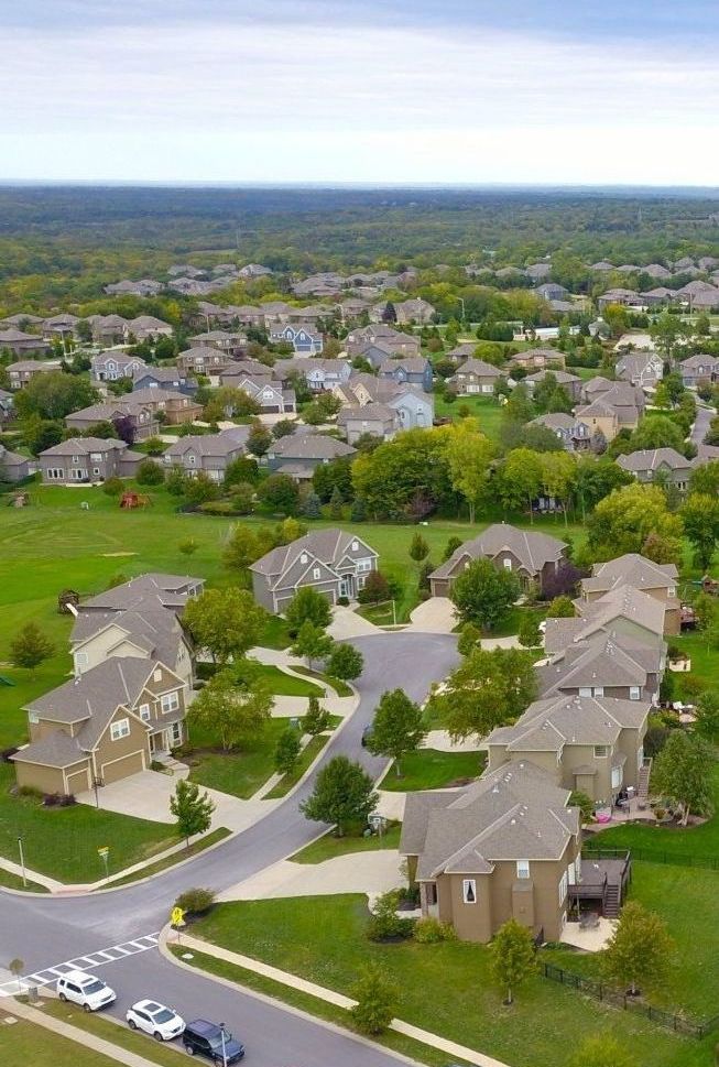 an aerial view of a residential neighborhood with lots of houses and trees .