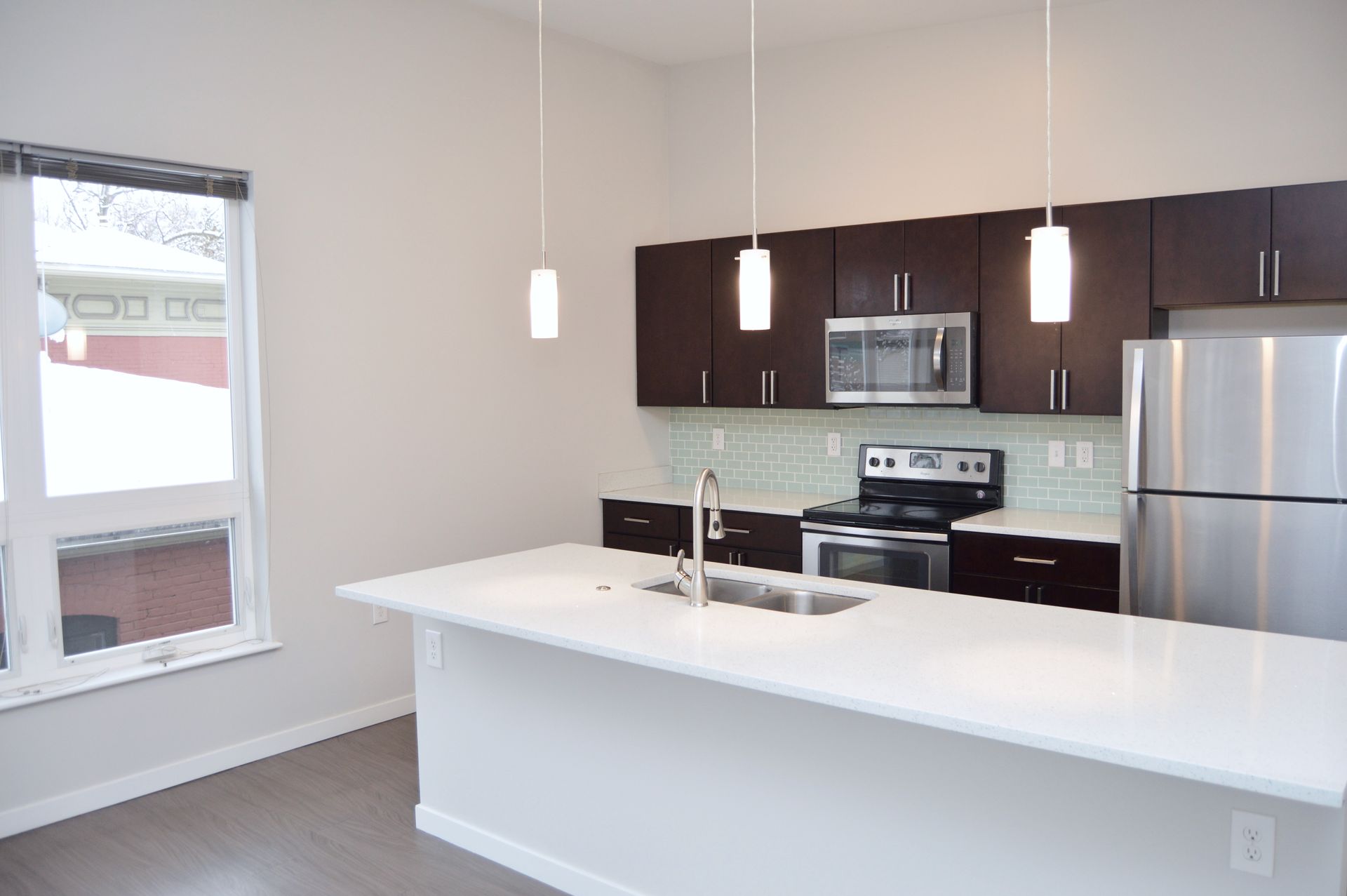 A kitchen with stainless steel appliances and brown cabinets