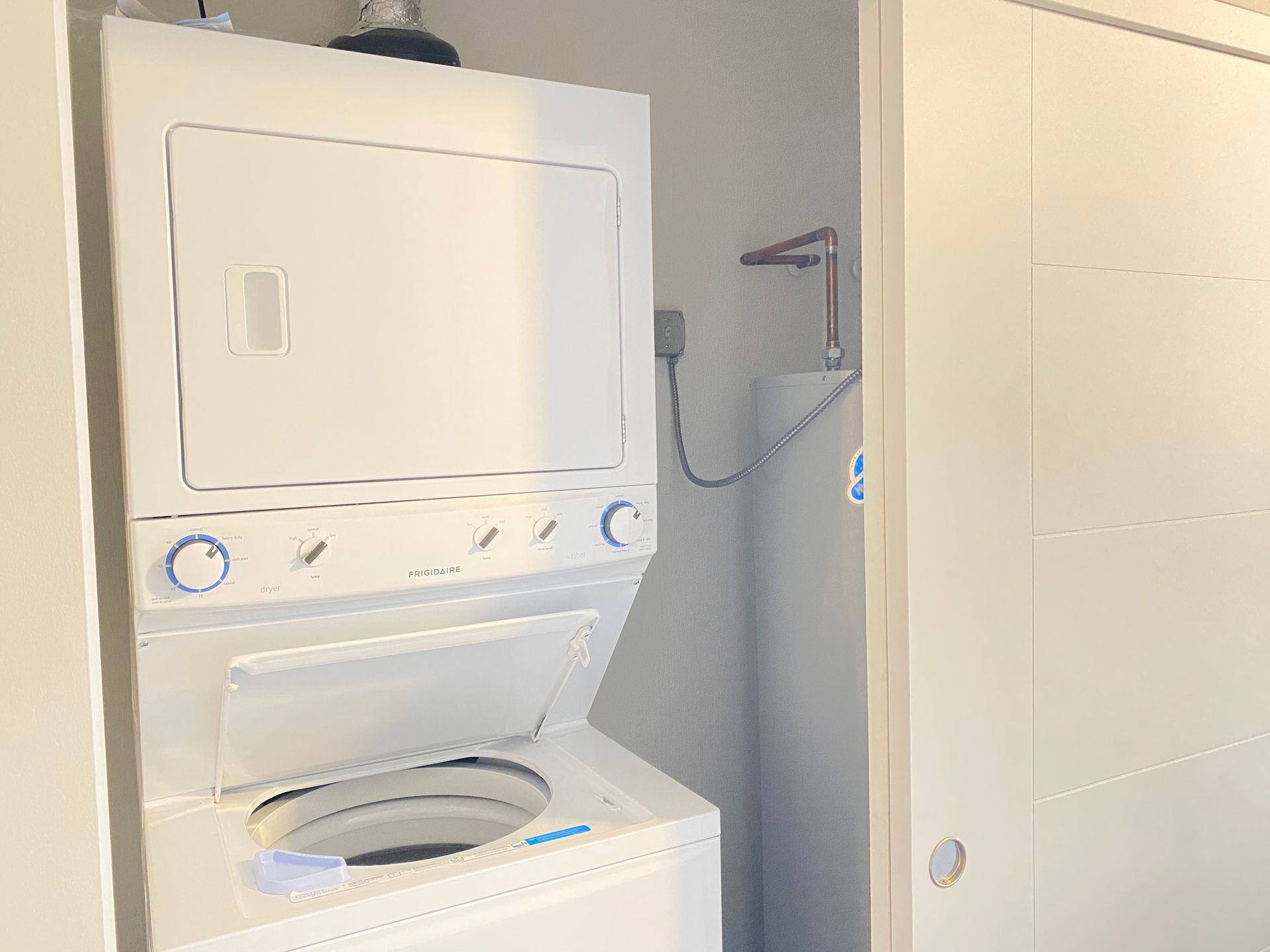 A washer and dryer are stacked on top of each other in a laundry room.