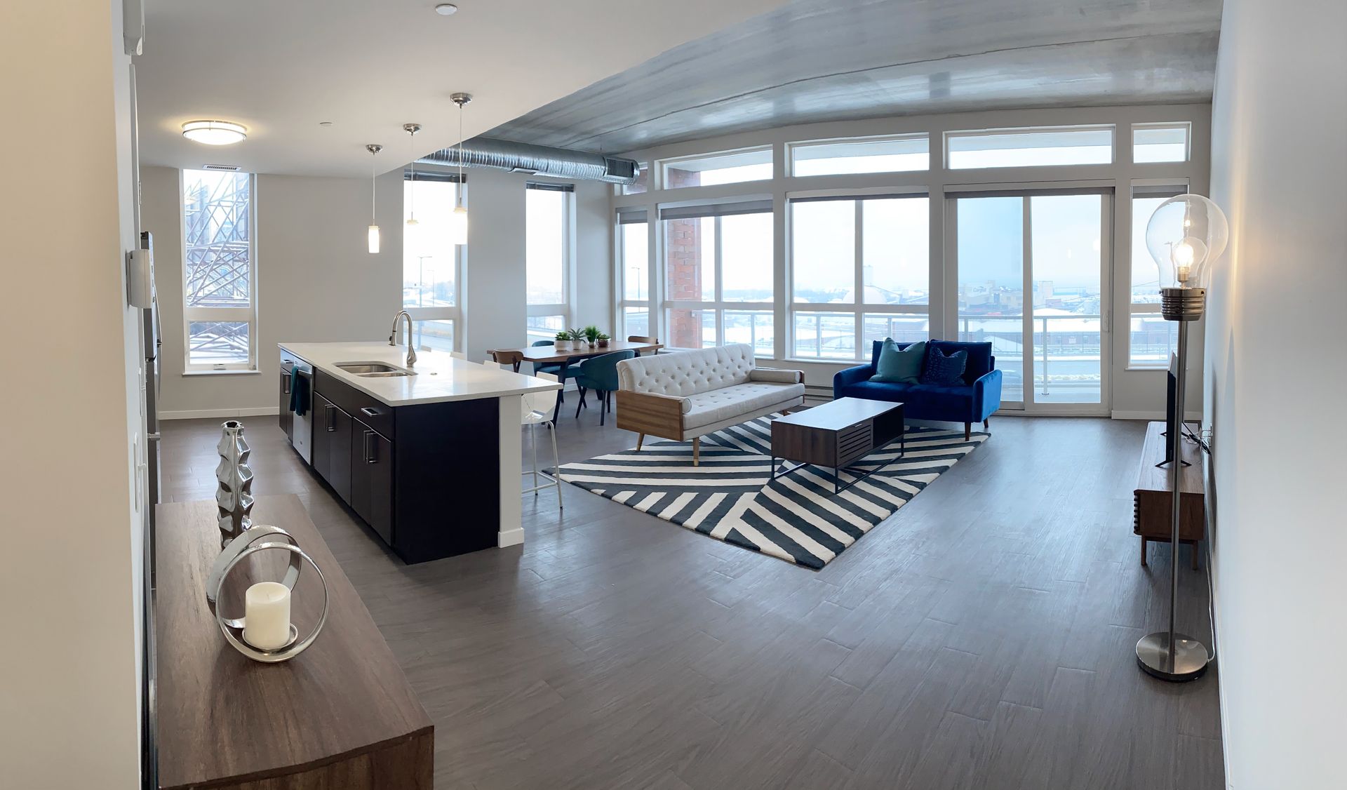 A large living room with a lot of windows and furniture.