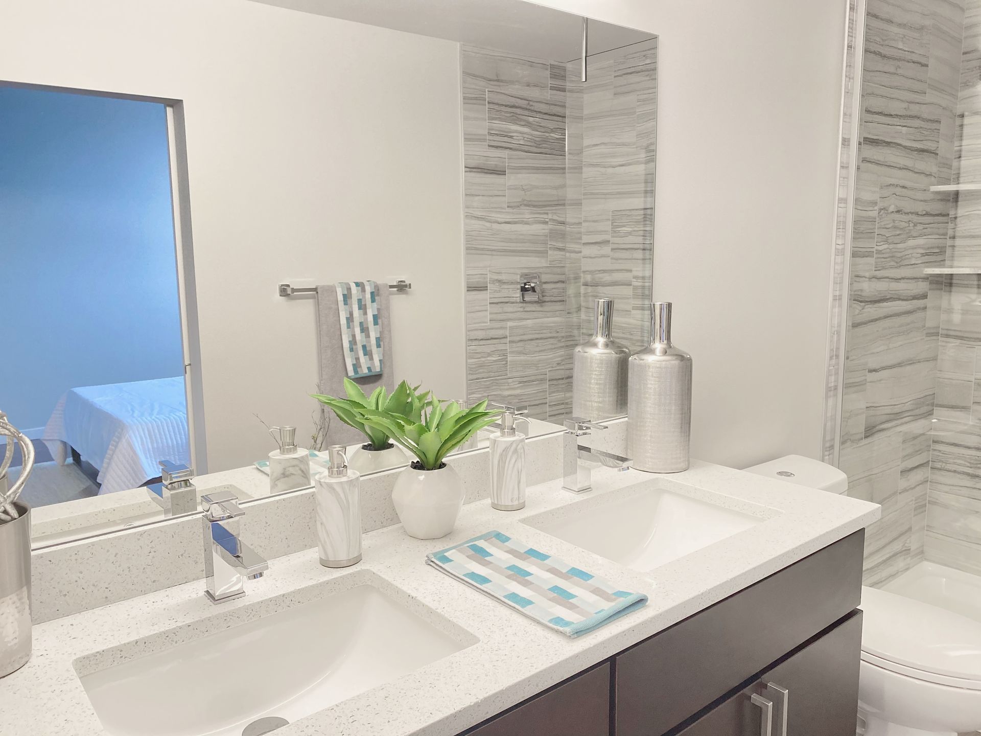 A bathroom with two sinks , a toilet and a mirror.