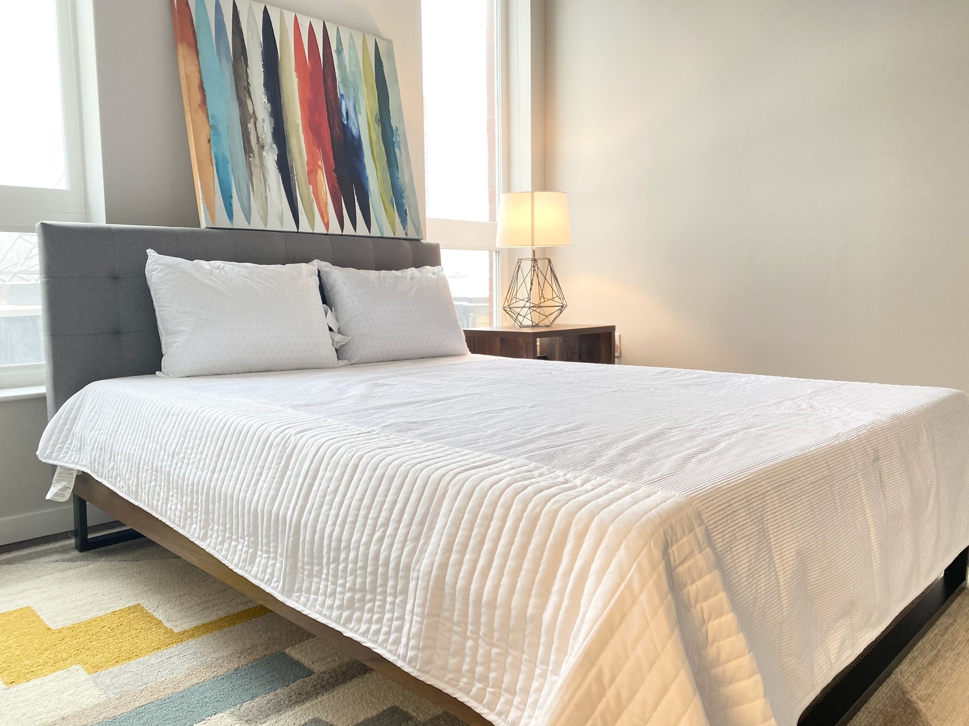 A bedroom with a bed and a painting on the wall above it