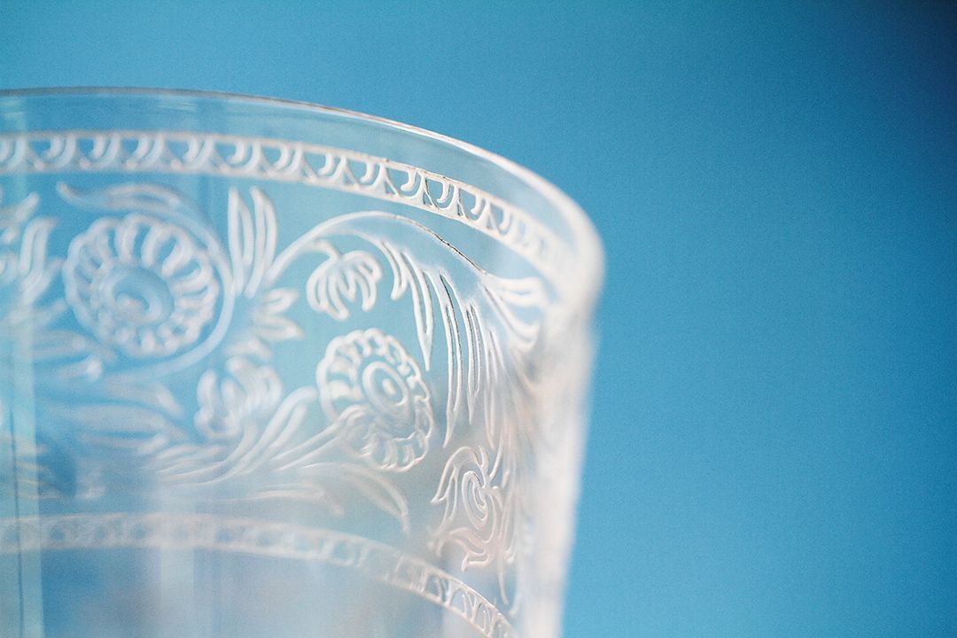 Un primer plano de un vaso con un diseño floral sobre un fondo azul.