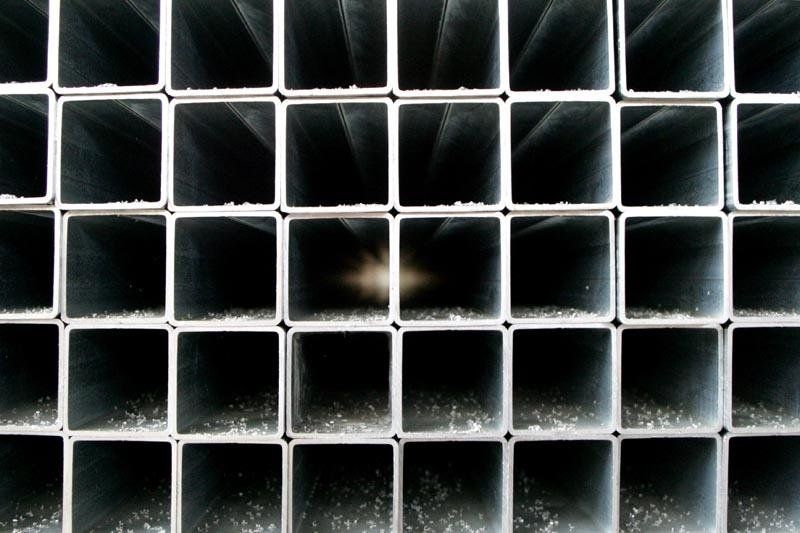 Un primo piano di una pila di tubi metallici quadrati