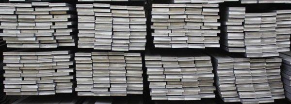 Un mucchio di libri sono accatastati uno sopra l'altro su uno scaffale.