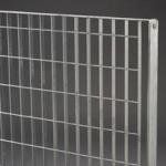 Un primo piano di una recinzione metallica su uno sfondo grigio.