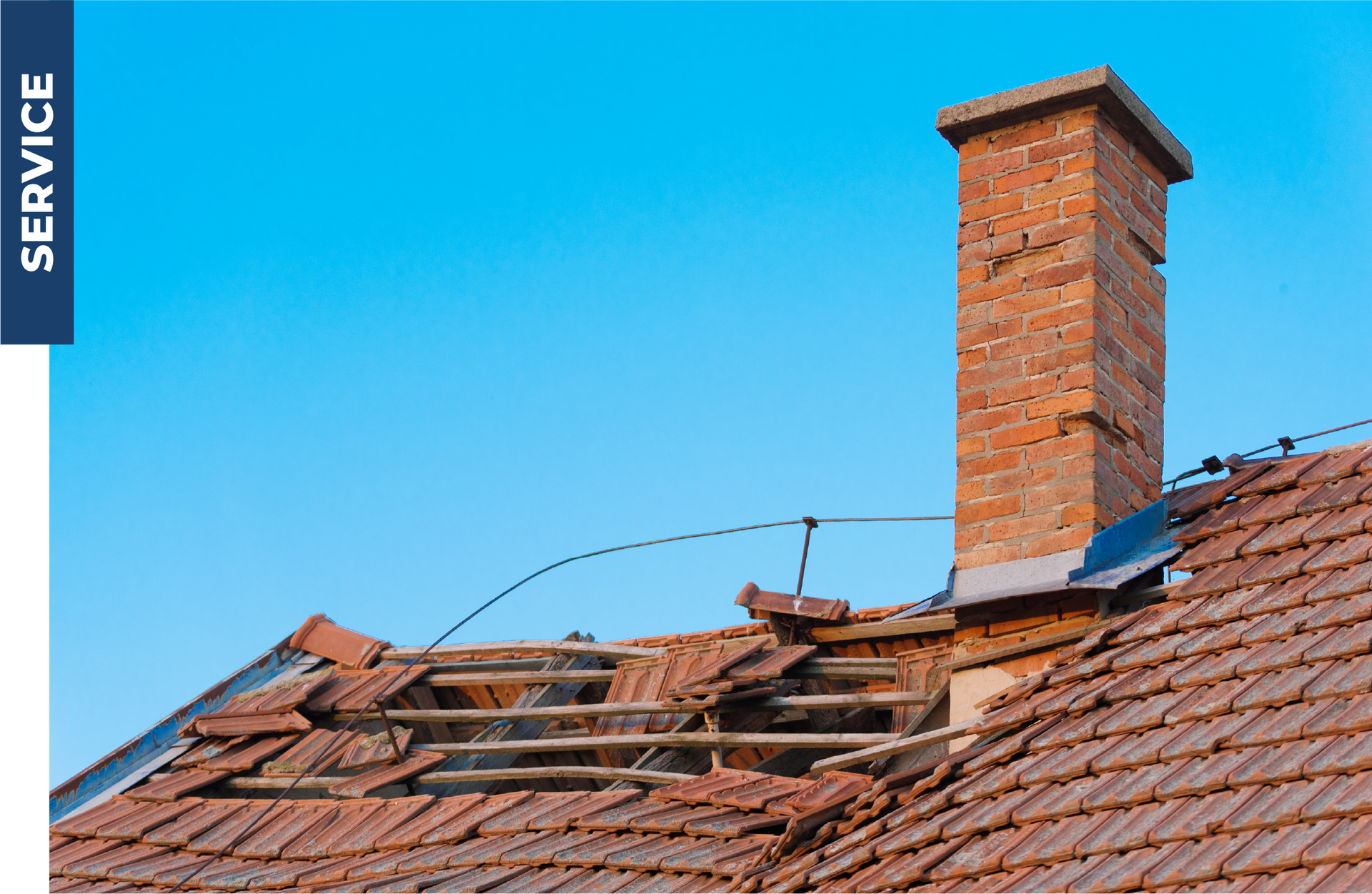 A brick chimney is sitting on top of a tiled roof.
