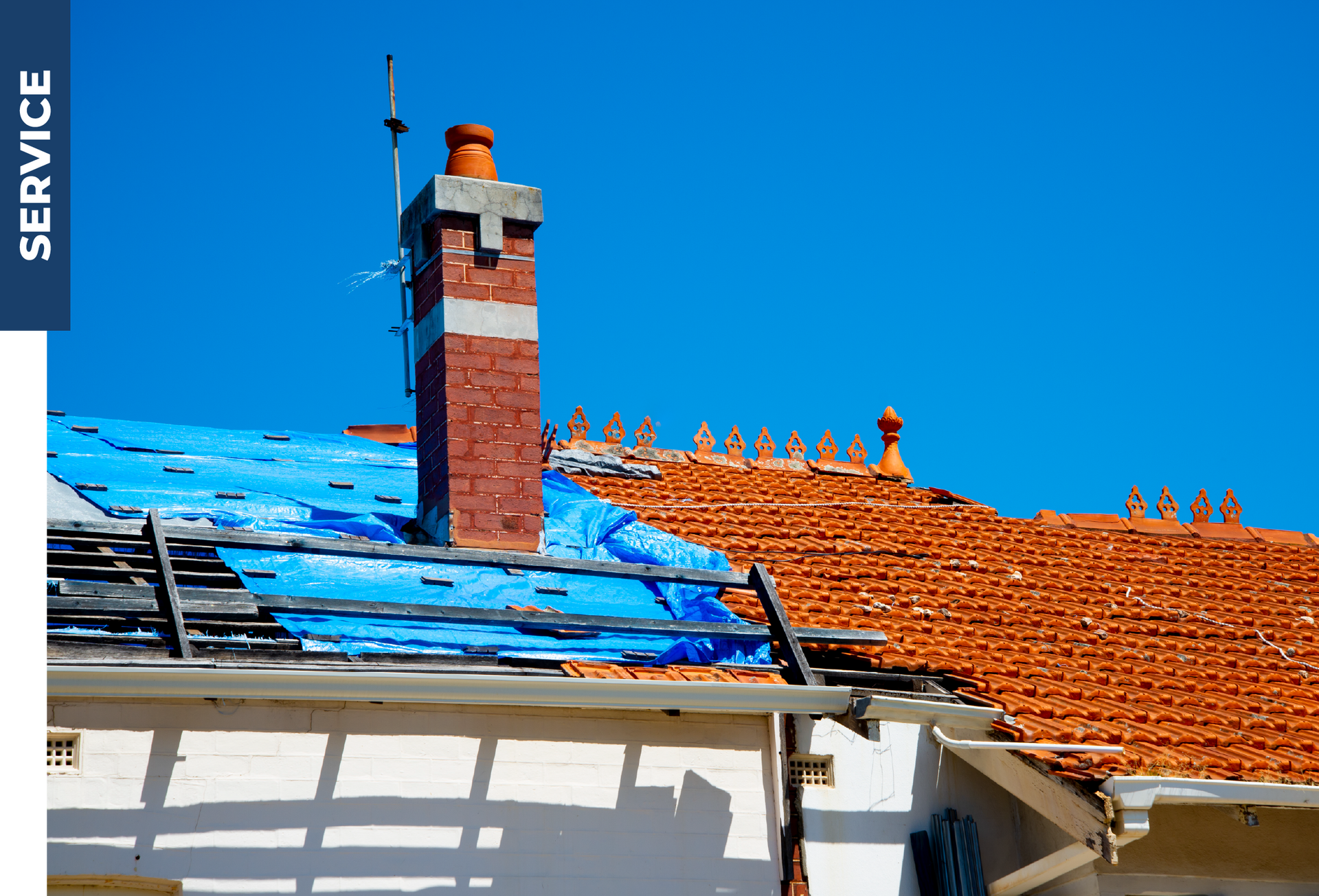 A blue tarp is covering the roof of a house