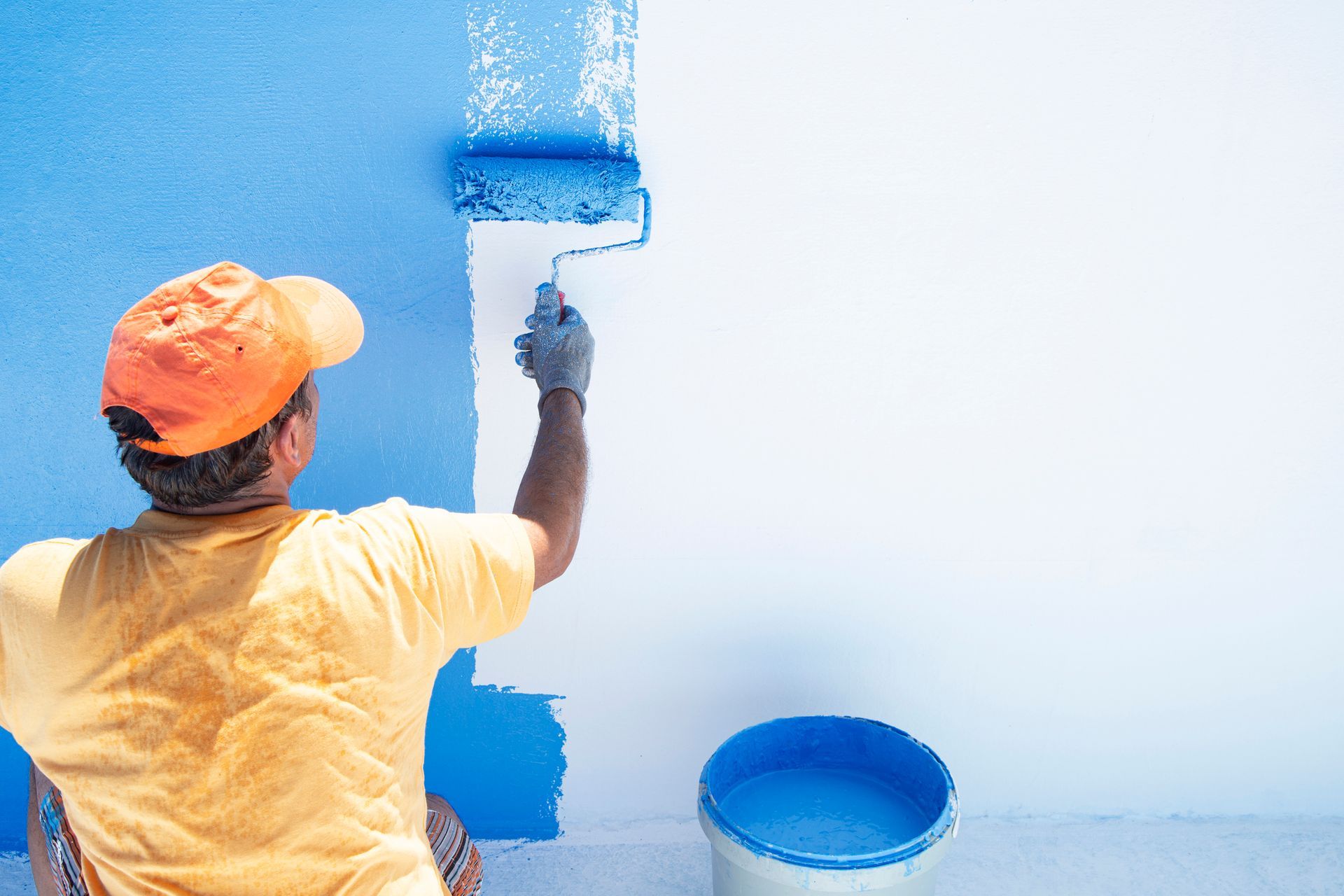 A man is plastering a ceiling with a trowel.