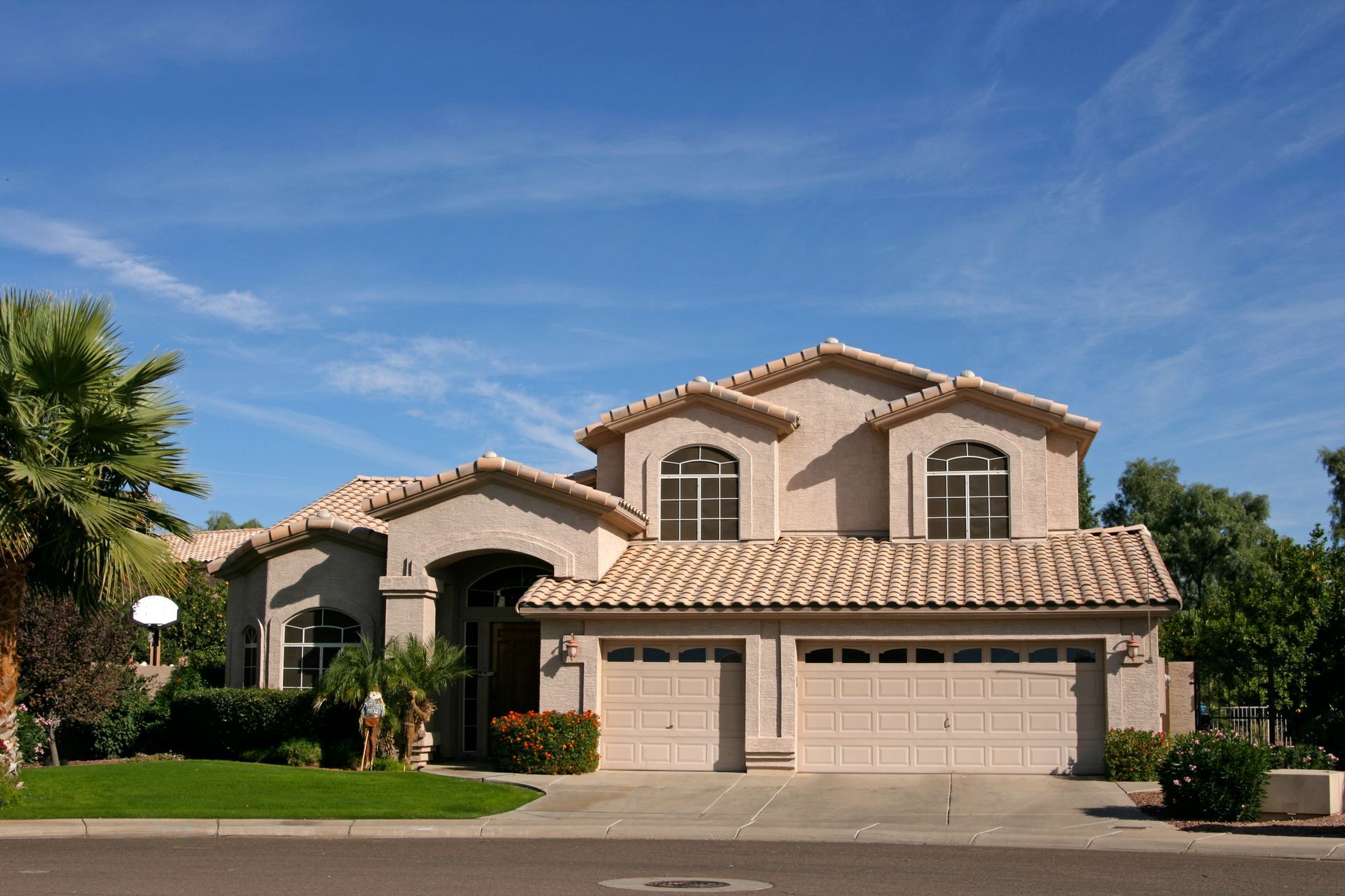 A large house with two garage doors and a tiled roof