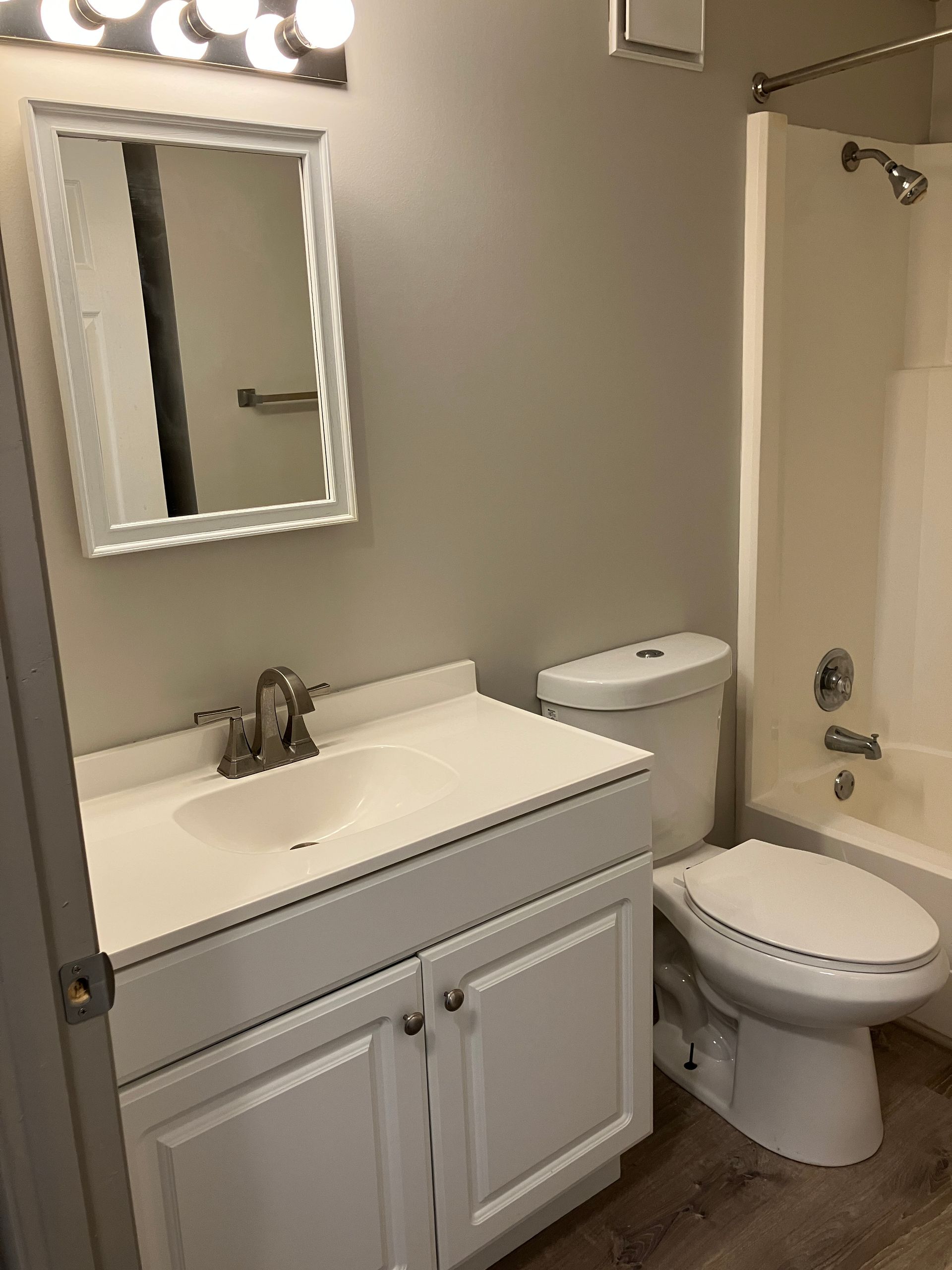 A bathroom with a sink , toilet , bathtub and mirror.