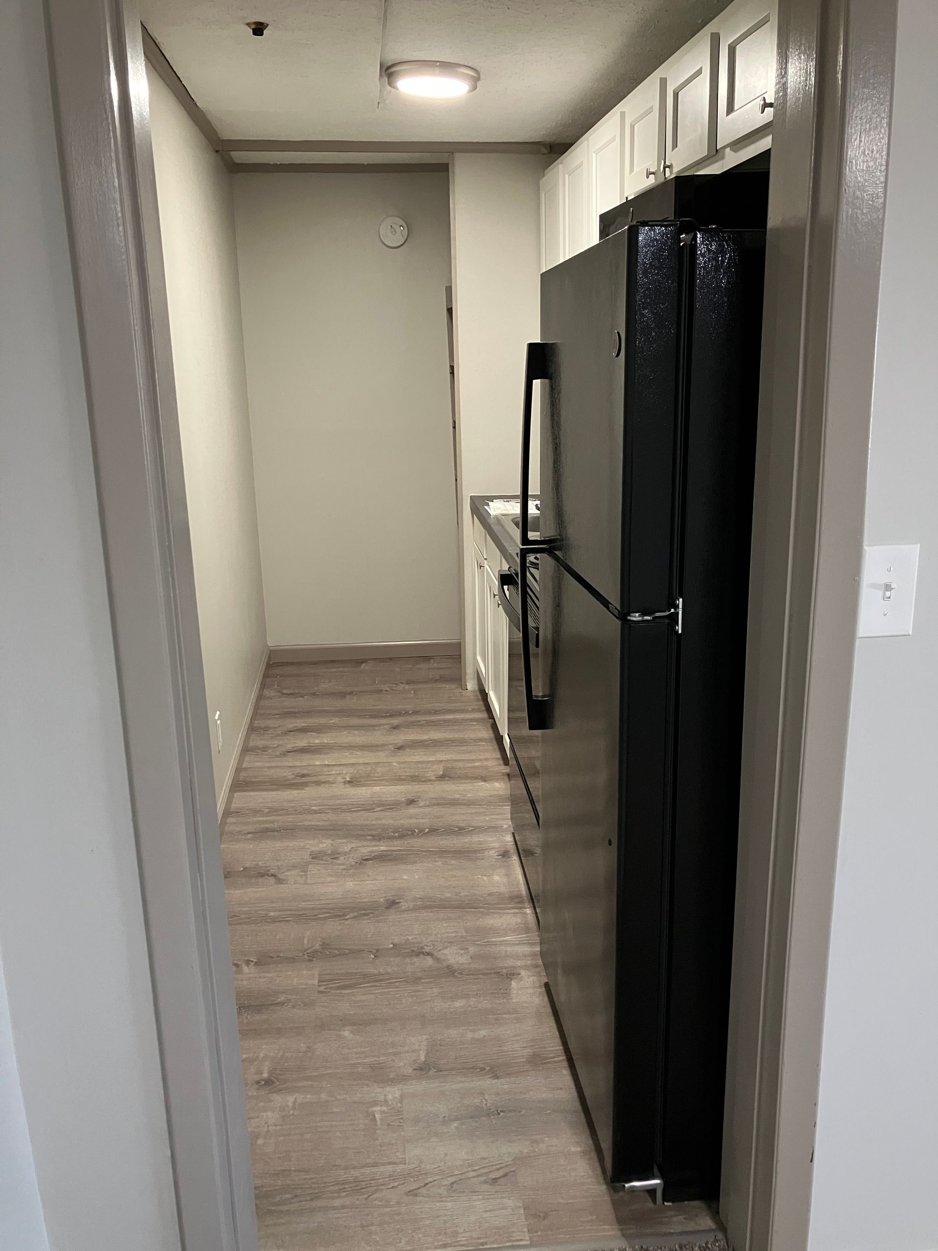 An empty bedroom with a ceiling fan and a window.