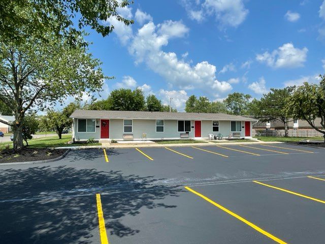 A motel with a parking lot in front of it