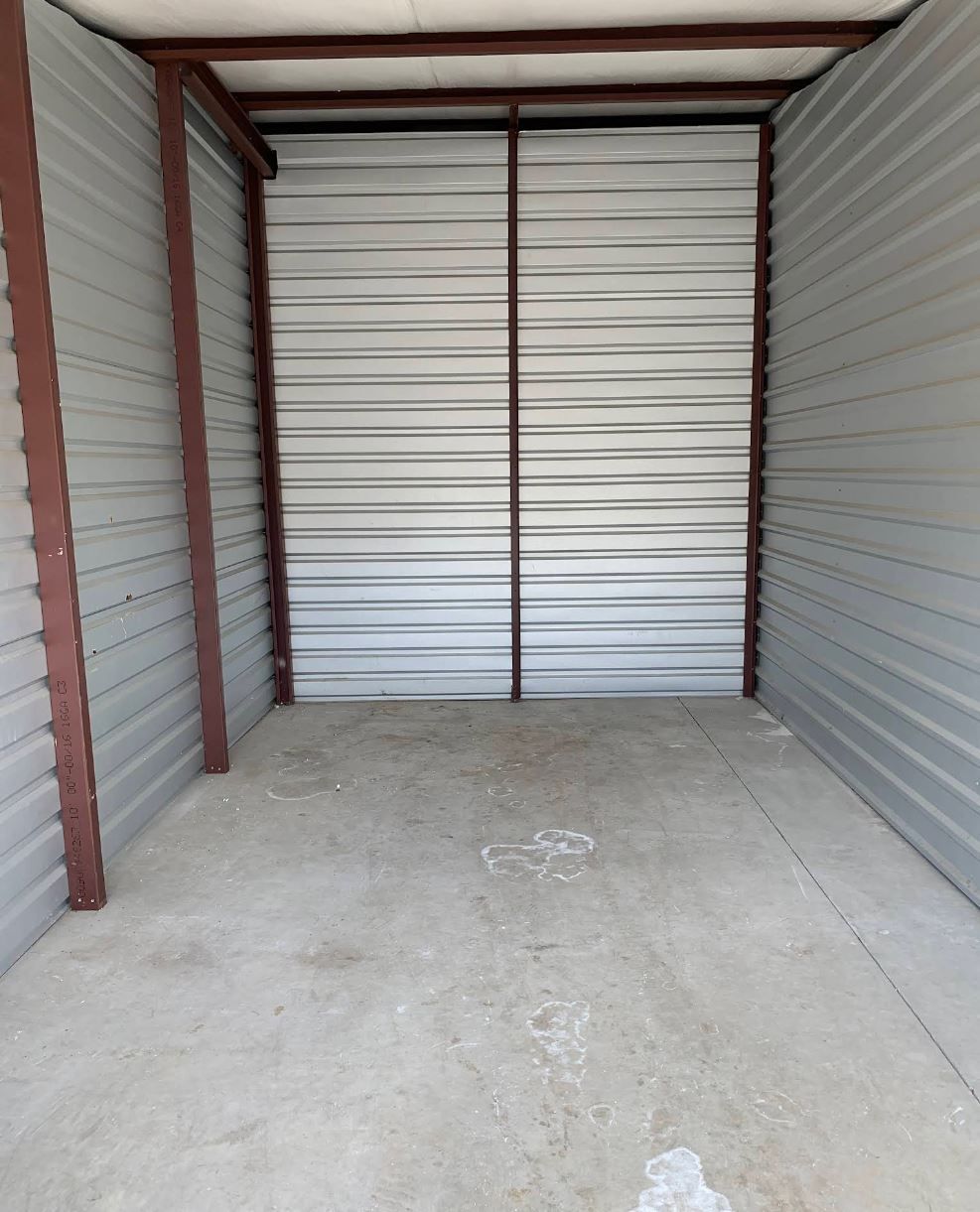 An empty room with a metal wall and a concrete floor