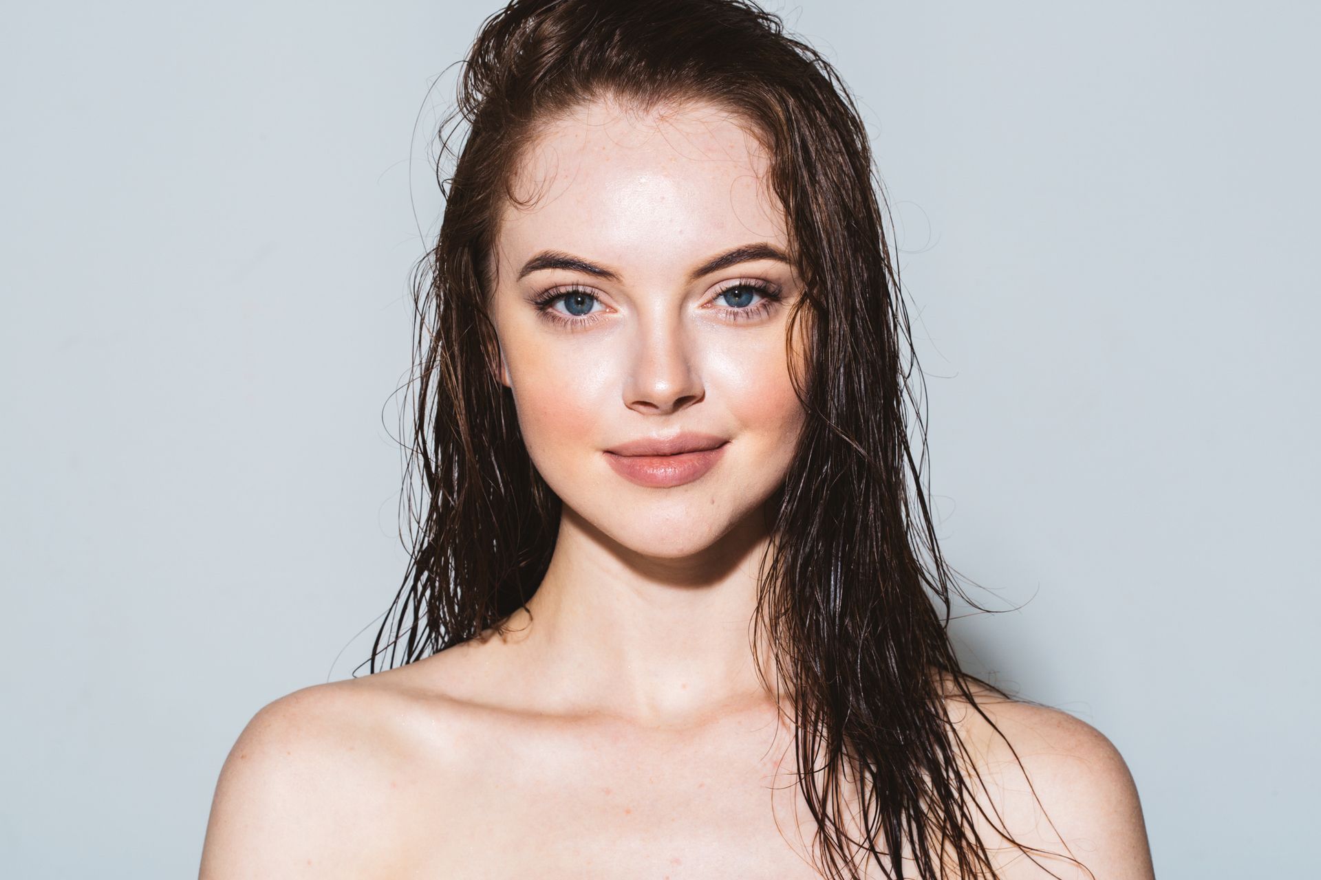 Woman with wet, brown hair, looking at the viewer. 