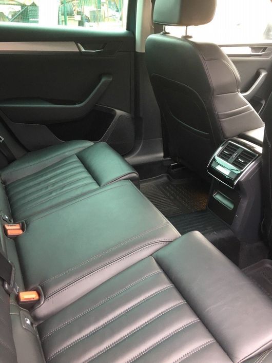 a comfortable back seat of a car with a grey seat cover
