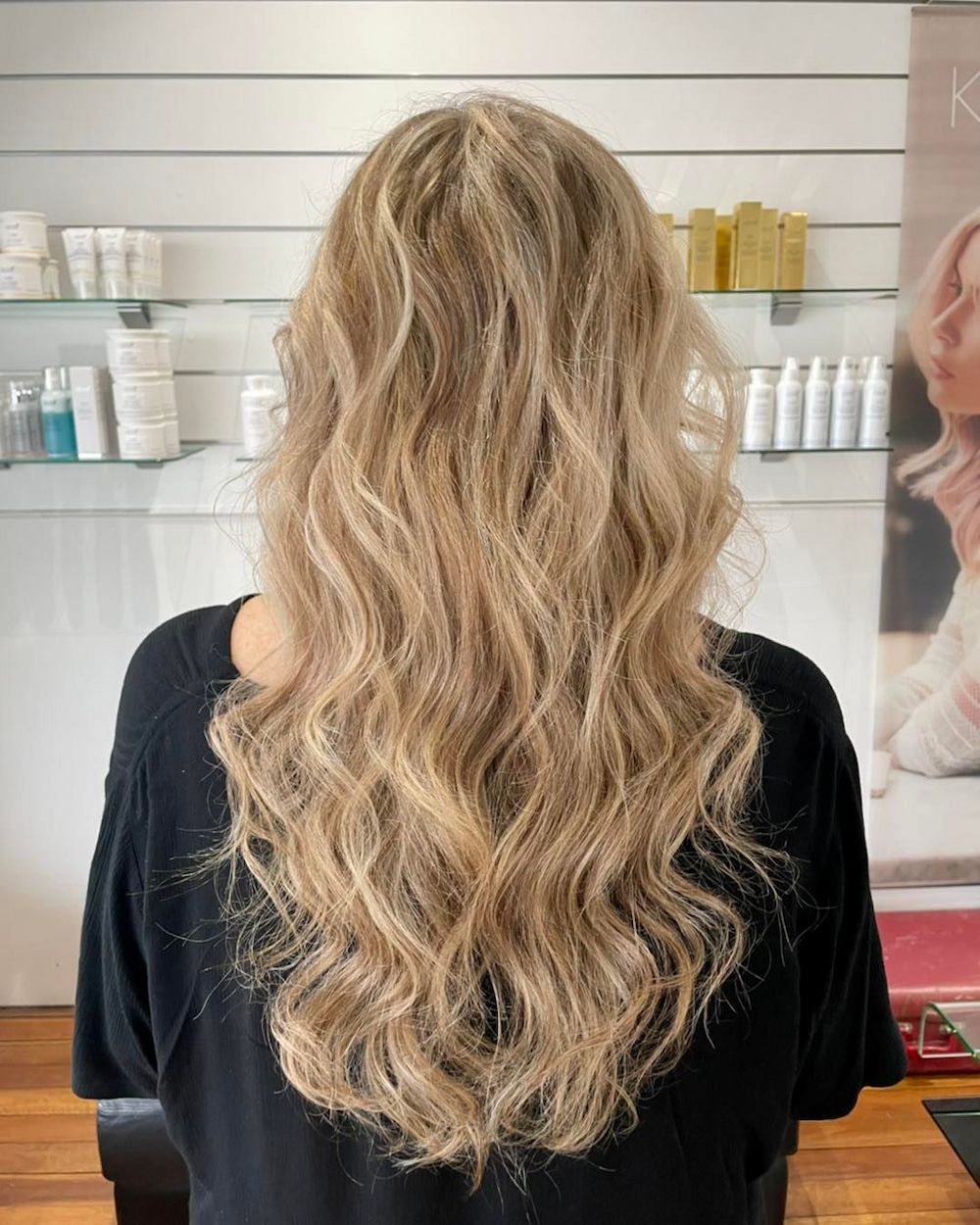Woman With Long, Wavy Blonde Hair in a Salon Setting — Strut Hair & Beauty In Maroochydore, QLD