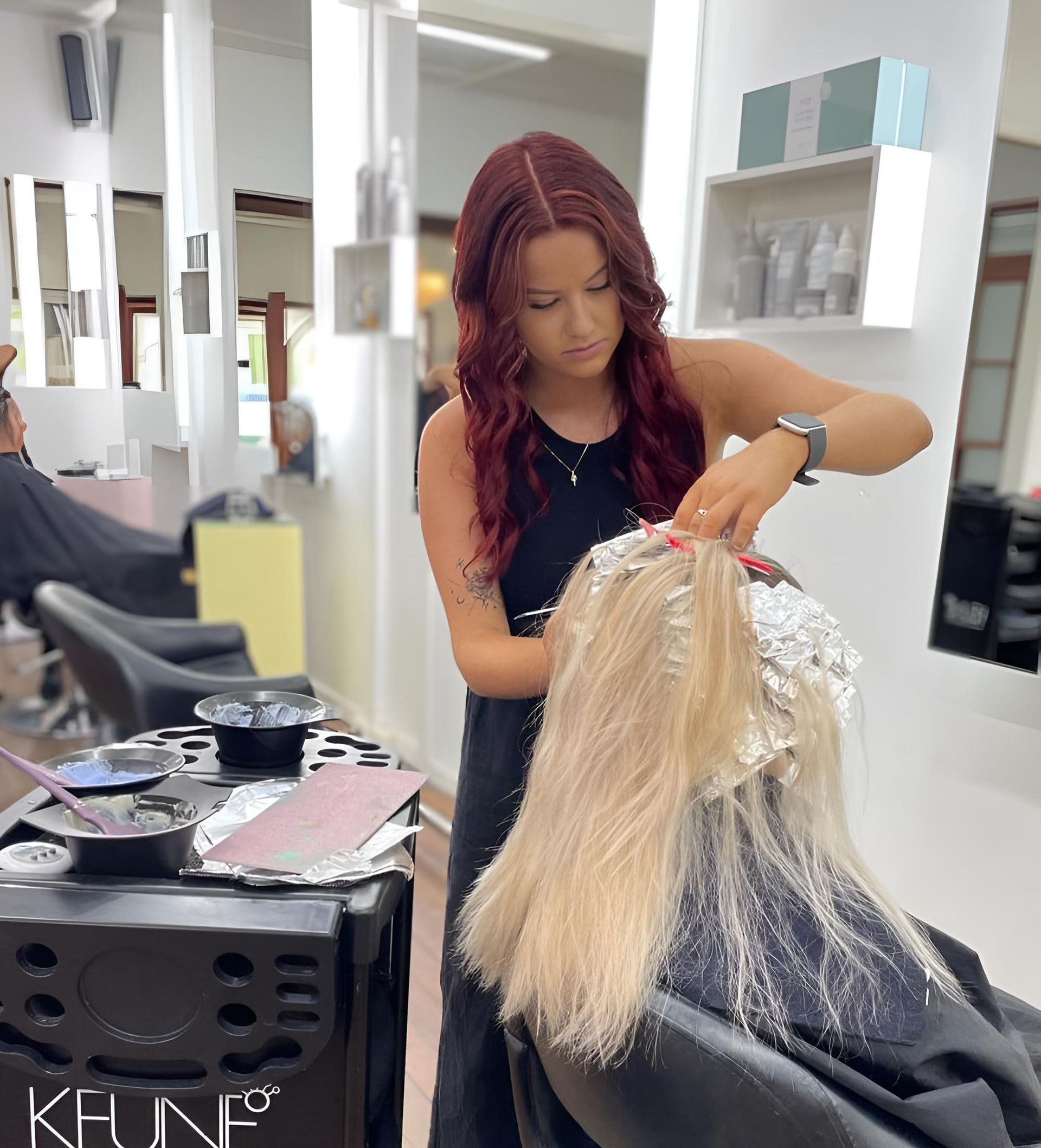 A Woman is Getting Her Hair Dyed in a Salon — Strut Hair & Beauty In Maroochydore, QLD