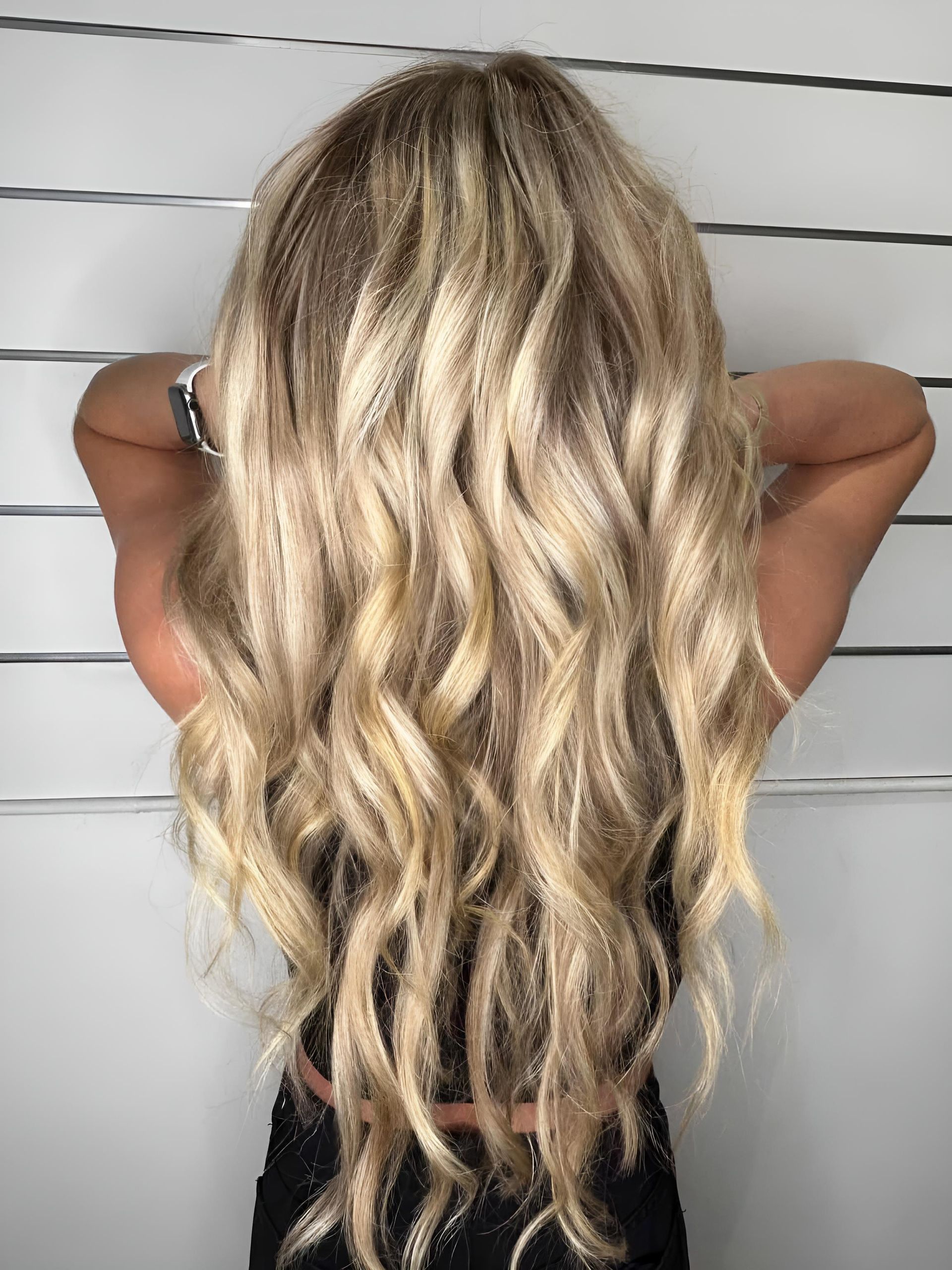 A Woman With Long Blonde Curly Hair — Strut Hair & Beauty In Maroochydore, QLD