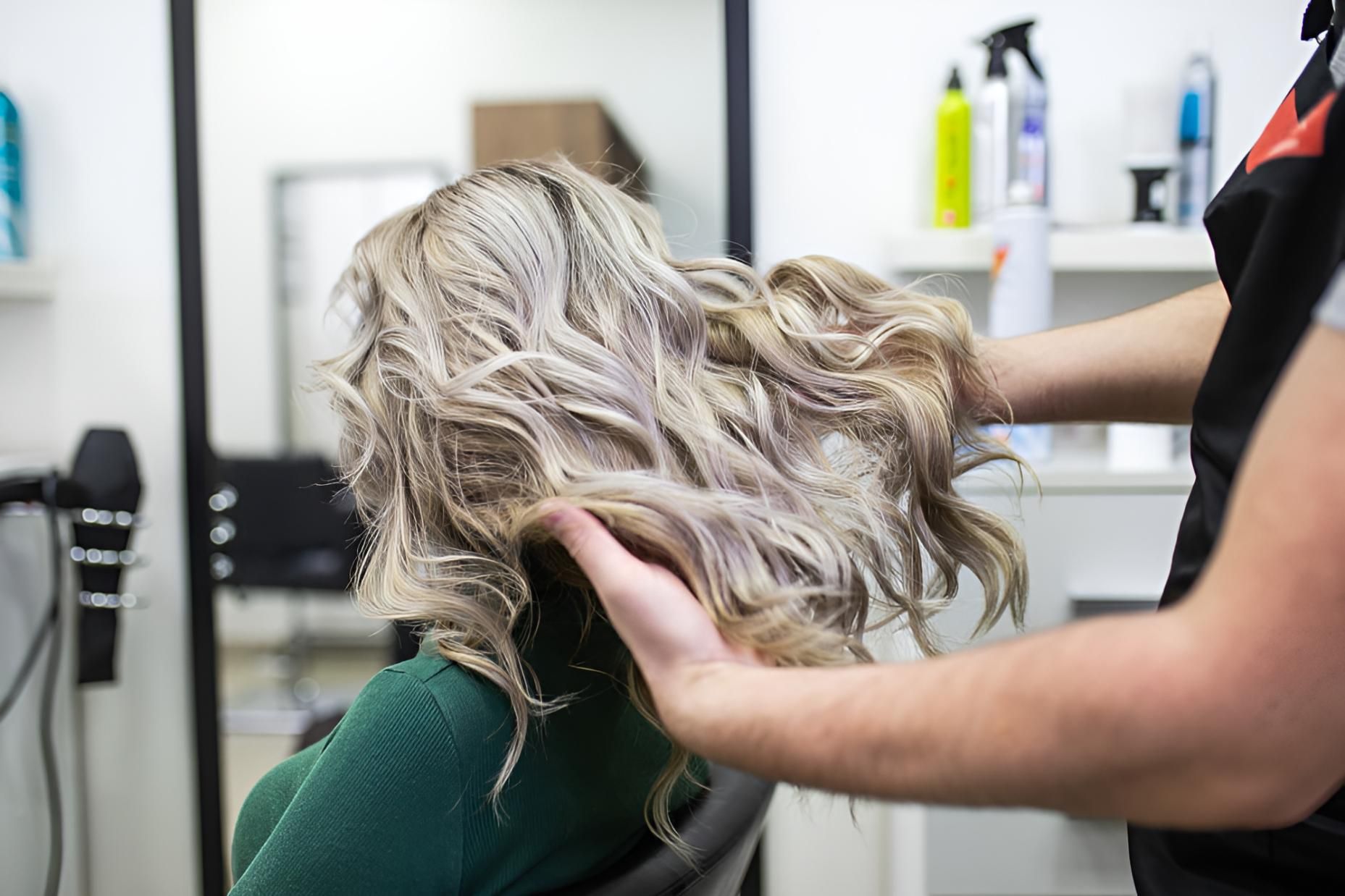 A Woman is Getting Her Hair Done by a Hairdresser in a Salon — Strut Hair & Beauty In Maroochydore, QLD