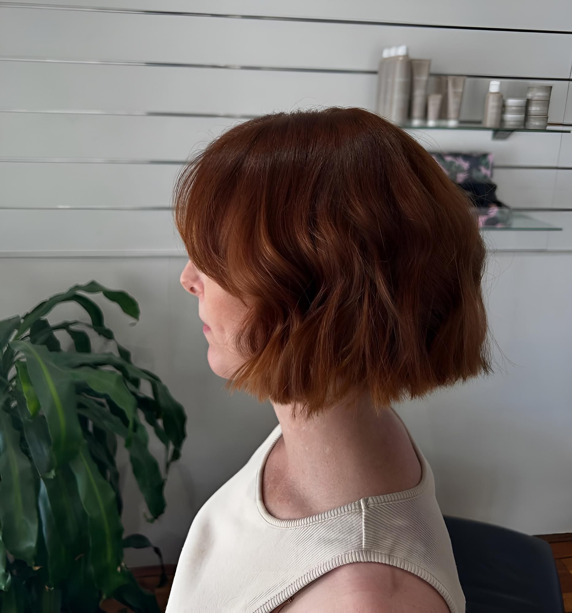 A Woman With Red Hair is Wearing a White Tank Top — Strut Hair & Beauty In Maroochydore, QLD