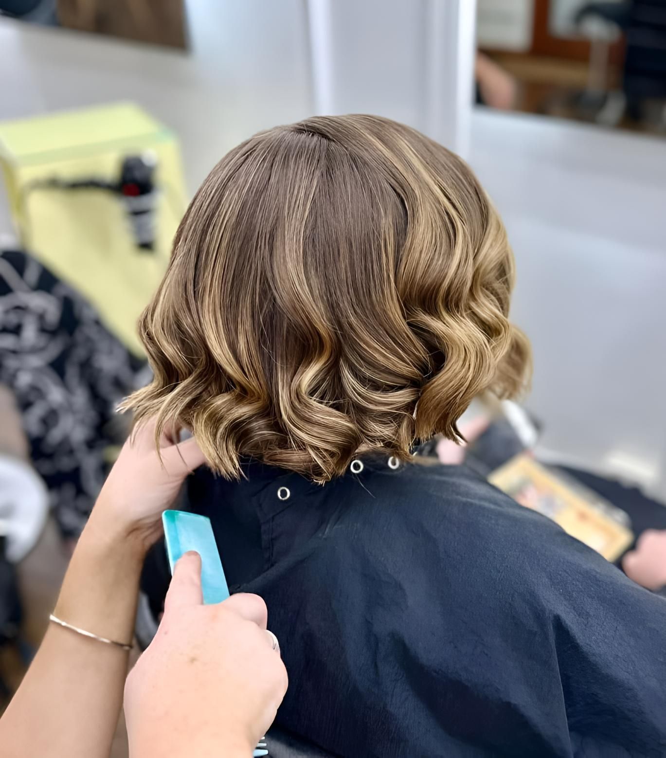 A Woman is Getting Her Hair Cut in a Salon — Strut Hair & Beauty In Maroochydore, QLD