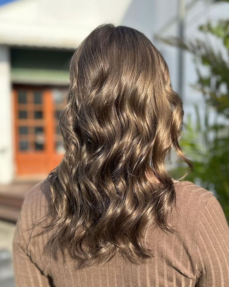 Woman With Wavy, Brown Hair and a Brown Sweater Outdoors — Strut Hair & Beauty In Maroochydore, QLD
