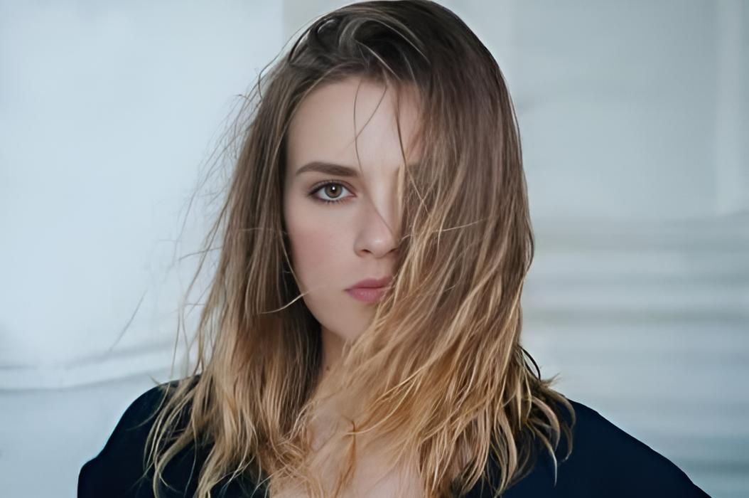 A Woman With Long Hair is Covering Her Face With Her Hair — Strut Hair & Beauty In Maroochydore, QLD