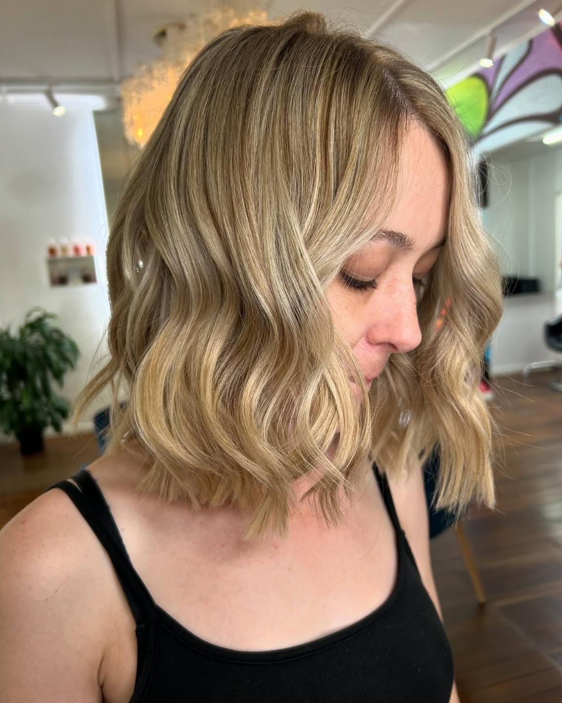 A Woman With Blonde Hair is Wearing a Black Tank Top — Strut Hair & Beauty In Maroochydore, QLD