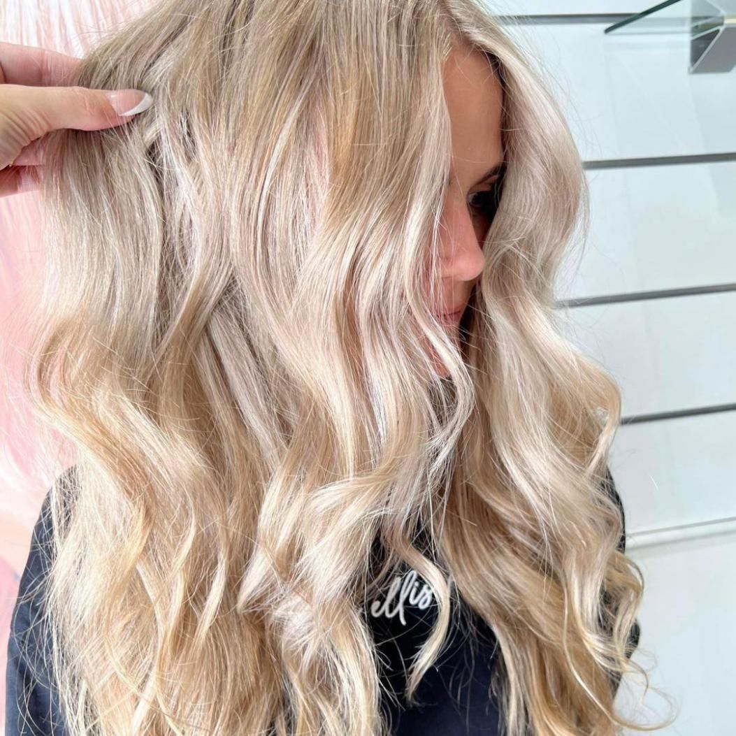 A Woman With Long Blonde Hair is Getting Her Hair Done in a Salon — Strut Hair & Beauty In Maroochydore, QLD