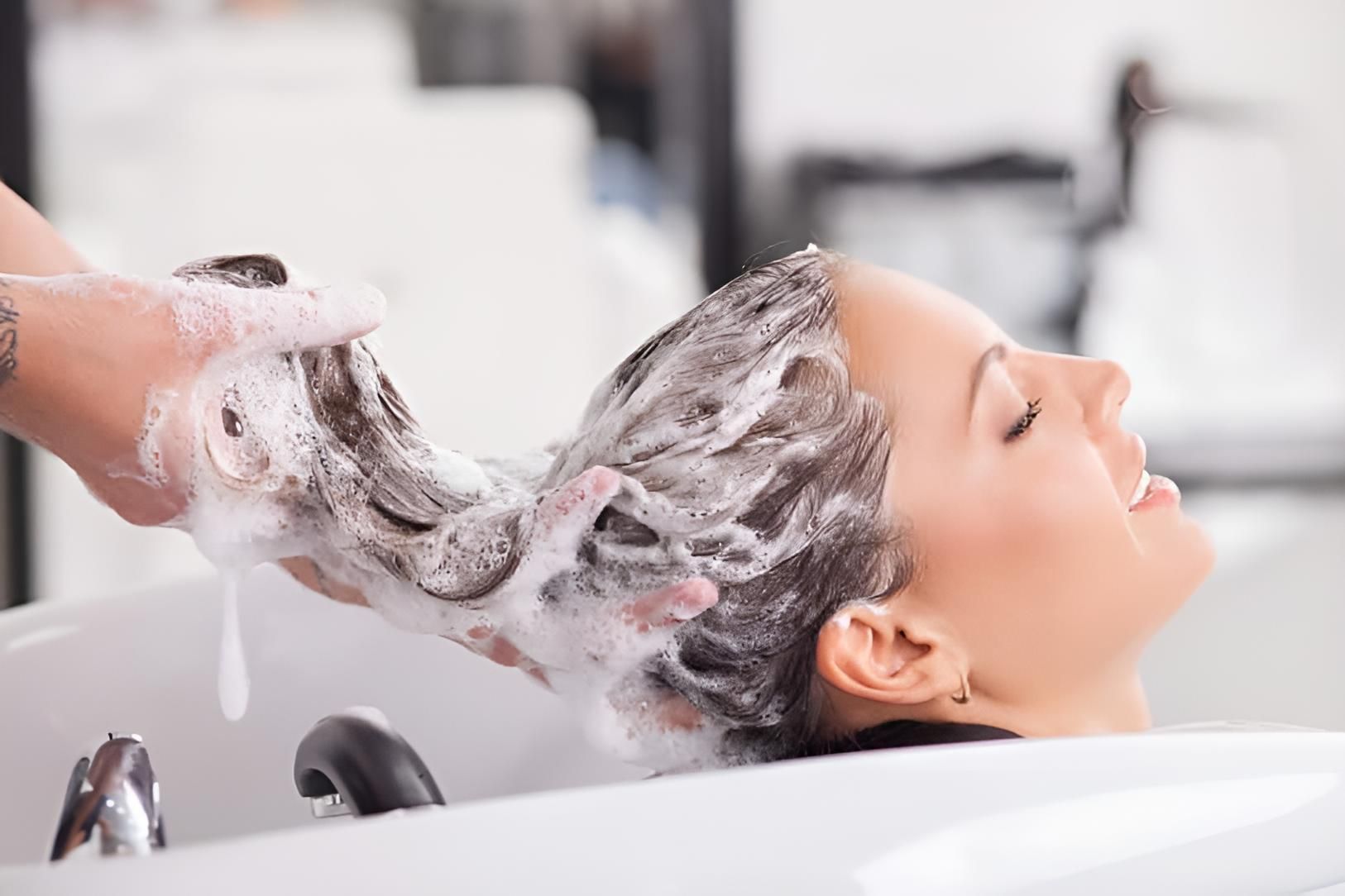A Woman is Getting Her Hair Washed at a Salon — Strut Hair & Beauty In Maroochydore, QLD