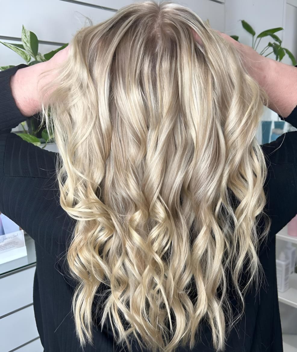 A Woman With Blonde Hair is Wearing a Black Shirt — Strut Hair & Beauty In Maroochydore, QLD