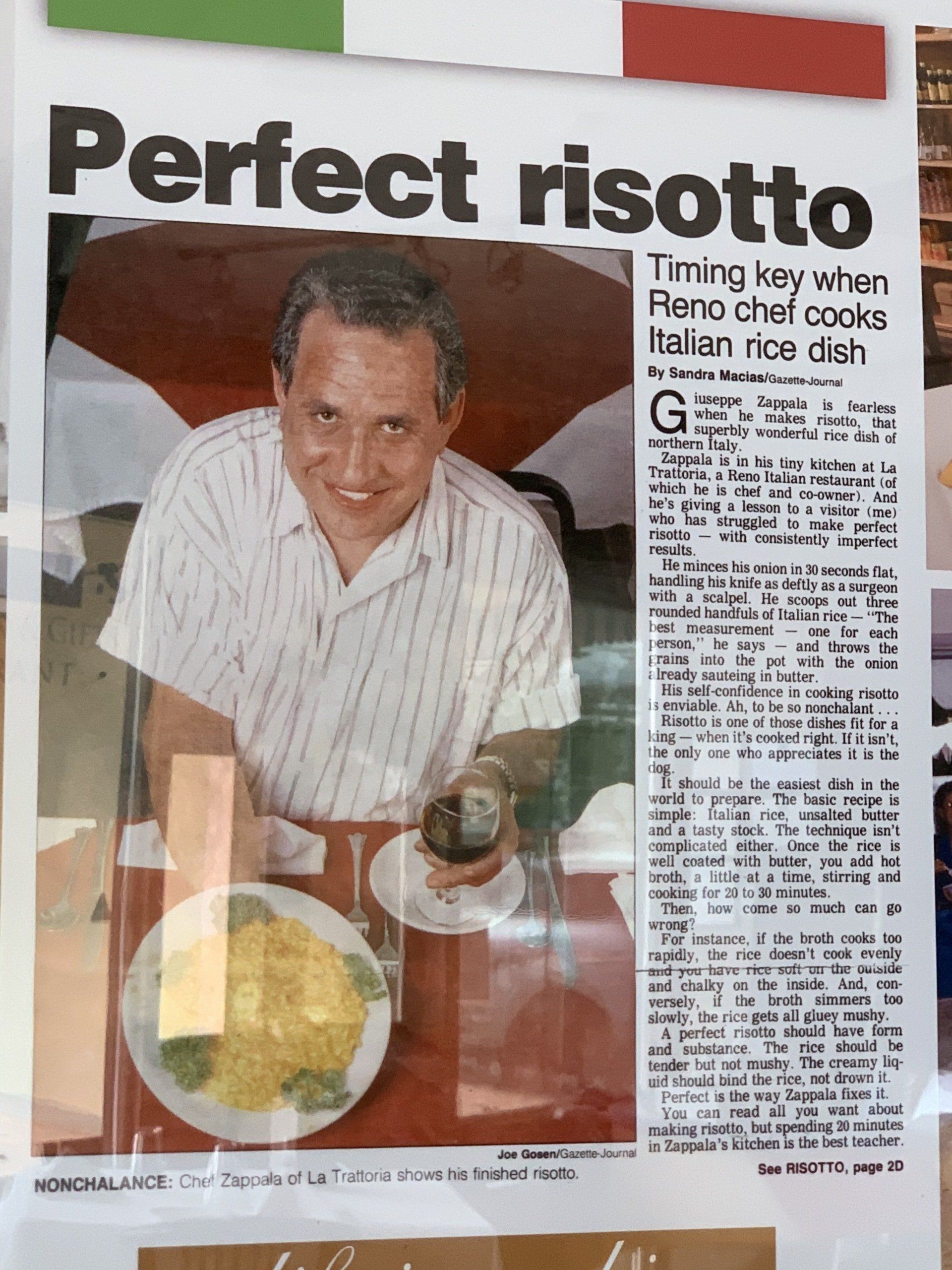 a man is sitting at a table with a plate of food and a newspaper article titled perfect risotto