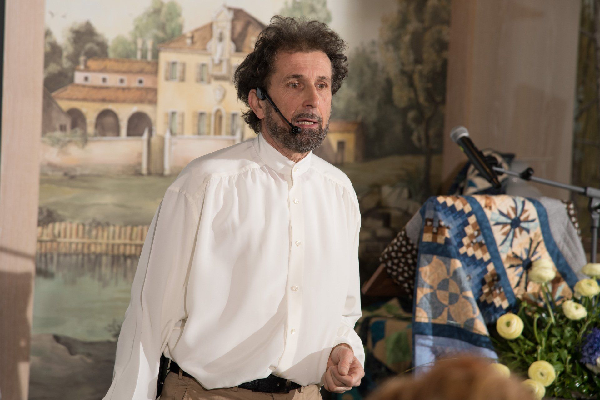 Un uomo con la barba è in piedi davanti a un microfono.