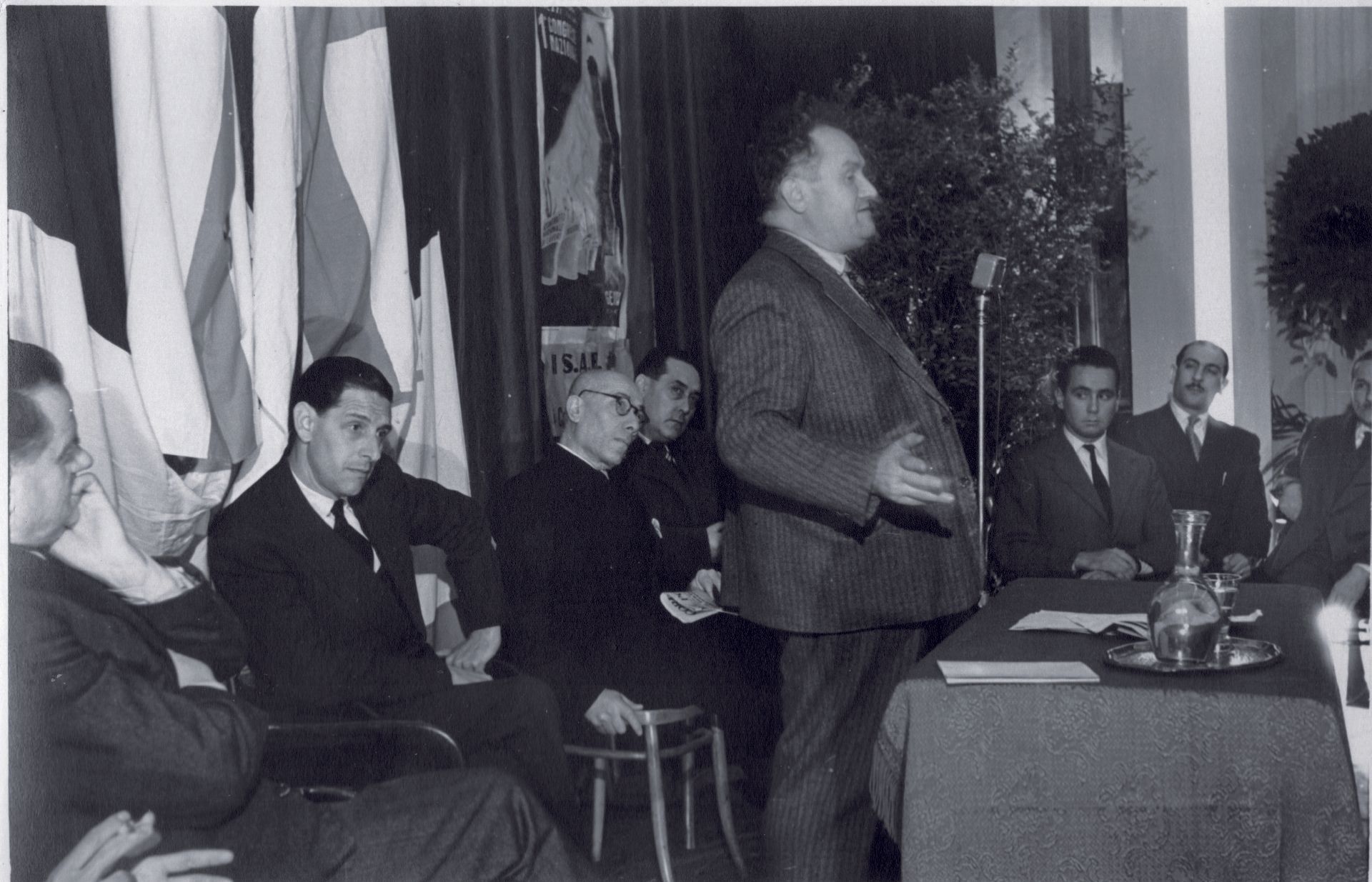 Una foto in bianco e nero di un uomo che tiene un discorso