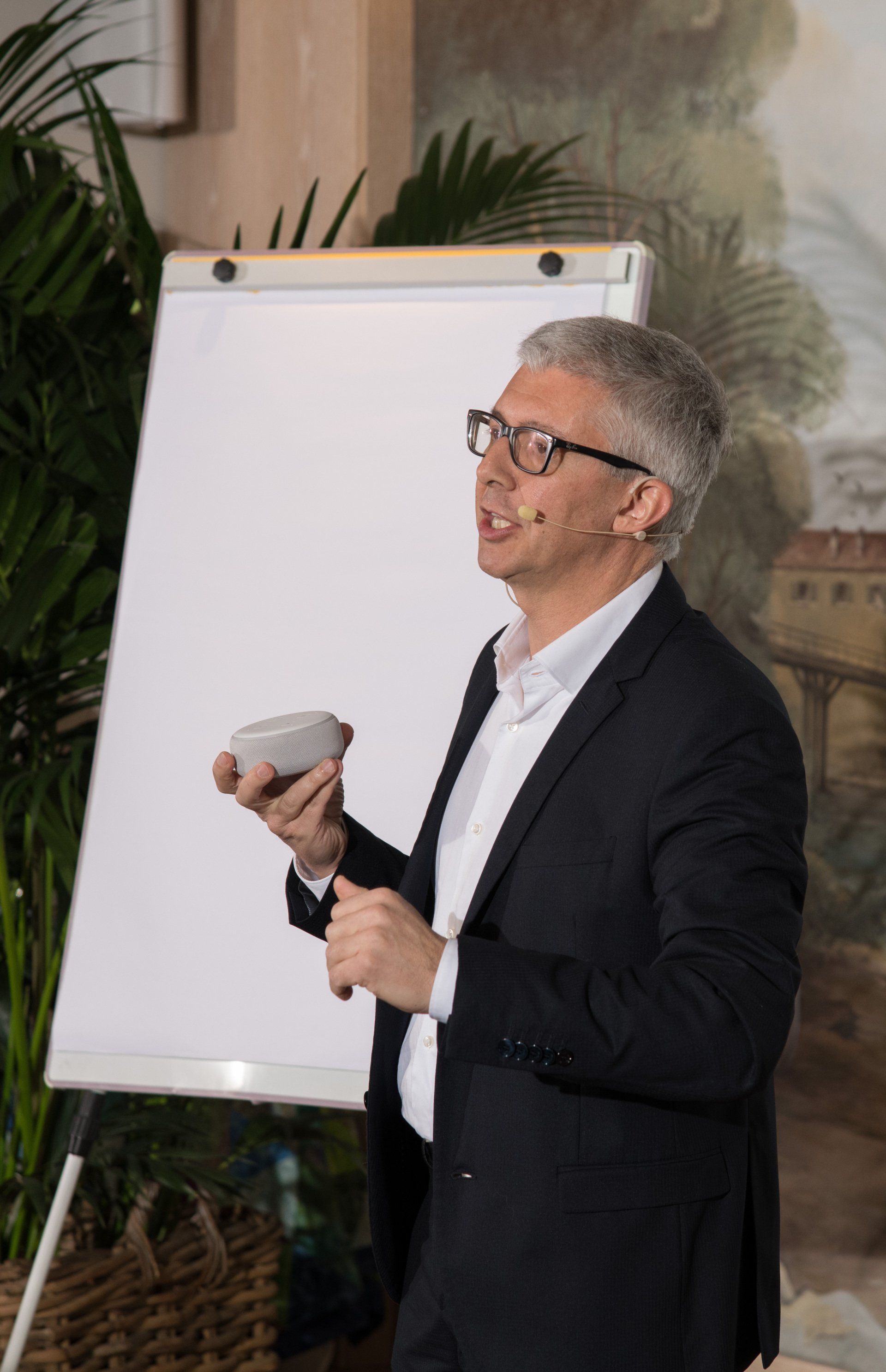 Un uomo in giacca e cravatta sta facendo una presentazione davanti a una lavagna.