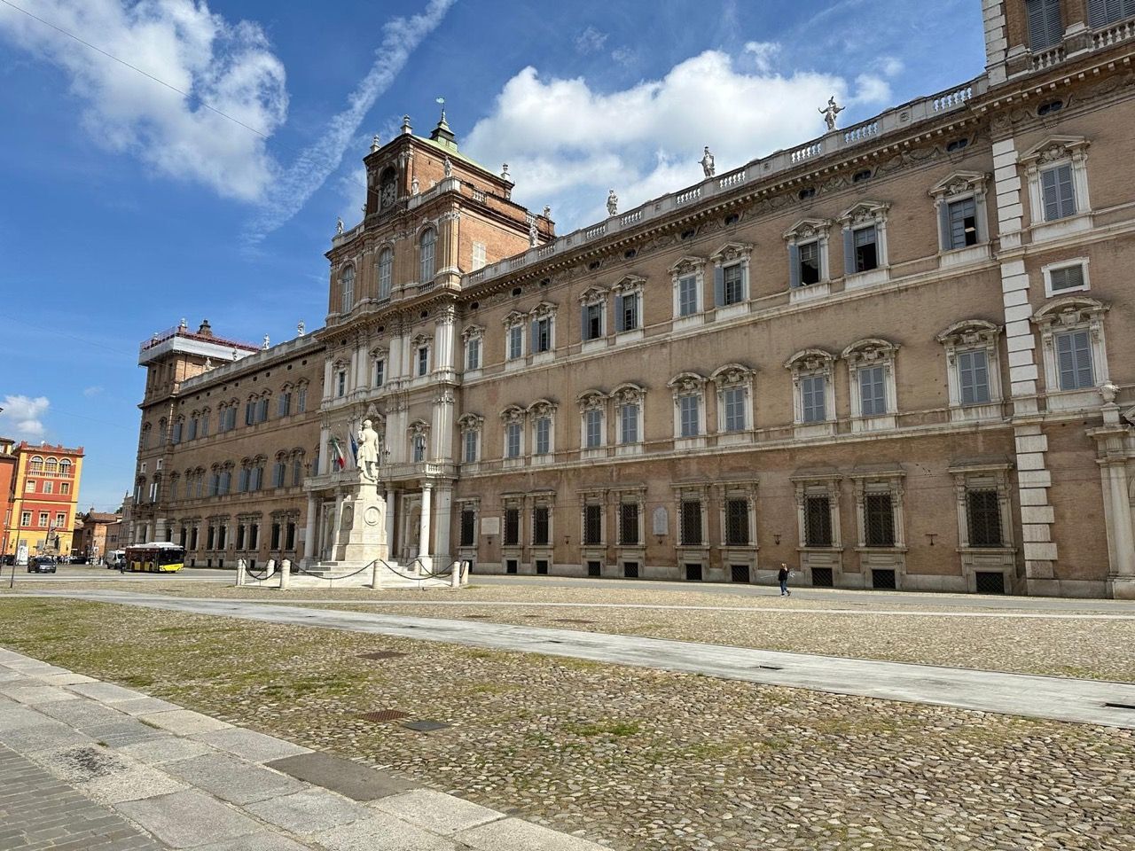 Un grande edificio con una statua di fronte.