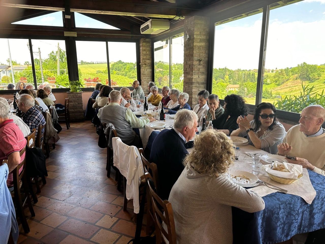 Un gruppo di persone è seduto ai tavoli di un ristorante.