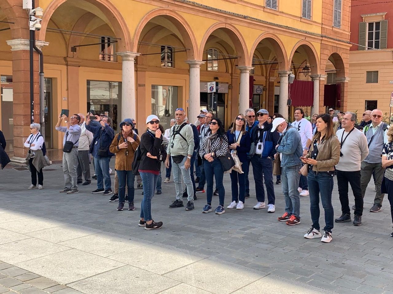 Un gruppo di persone è in piedi davanti a un edificio.
